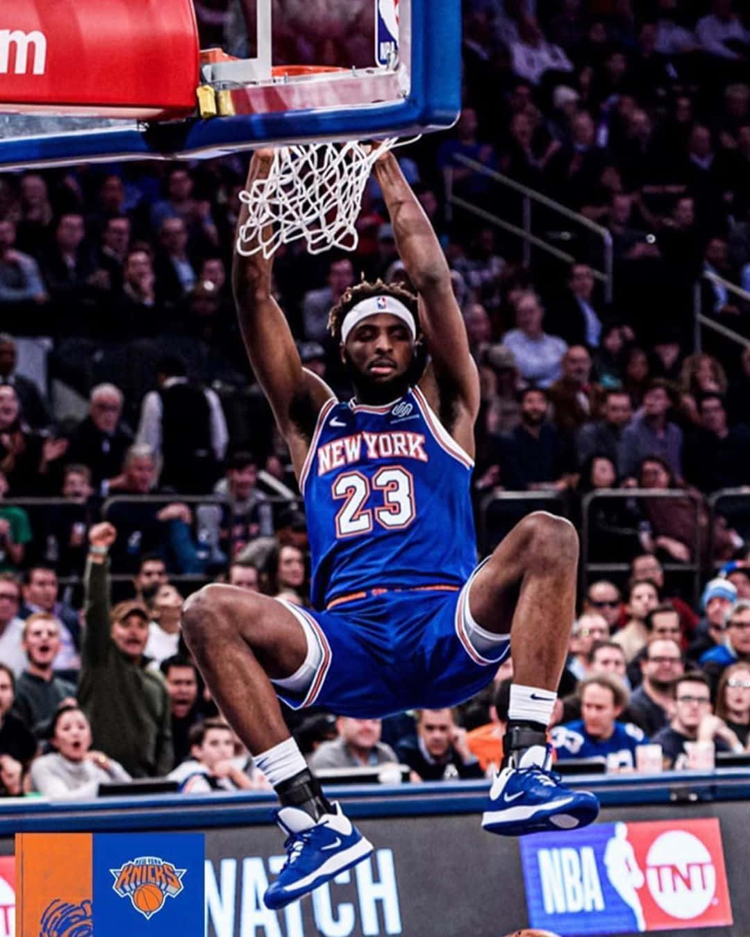 身穿藍色尼克隊球衣的籃球運動員在比賽中灌籃，觀眾歡呼。 — NBA 壁紙