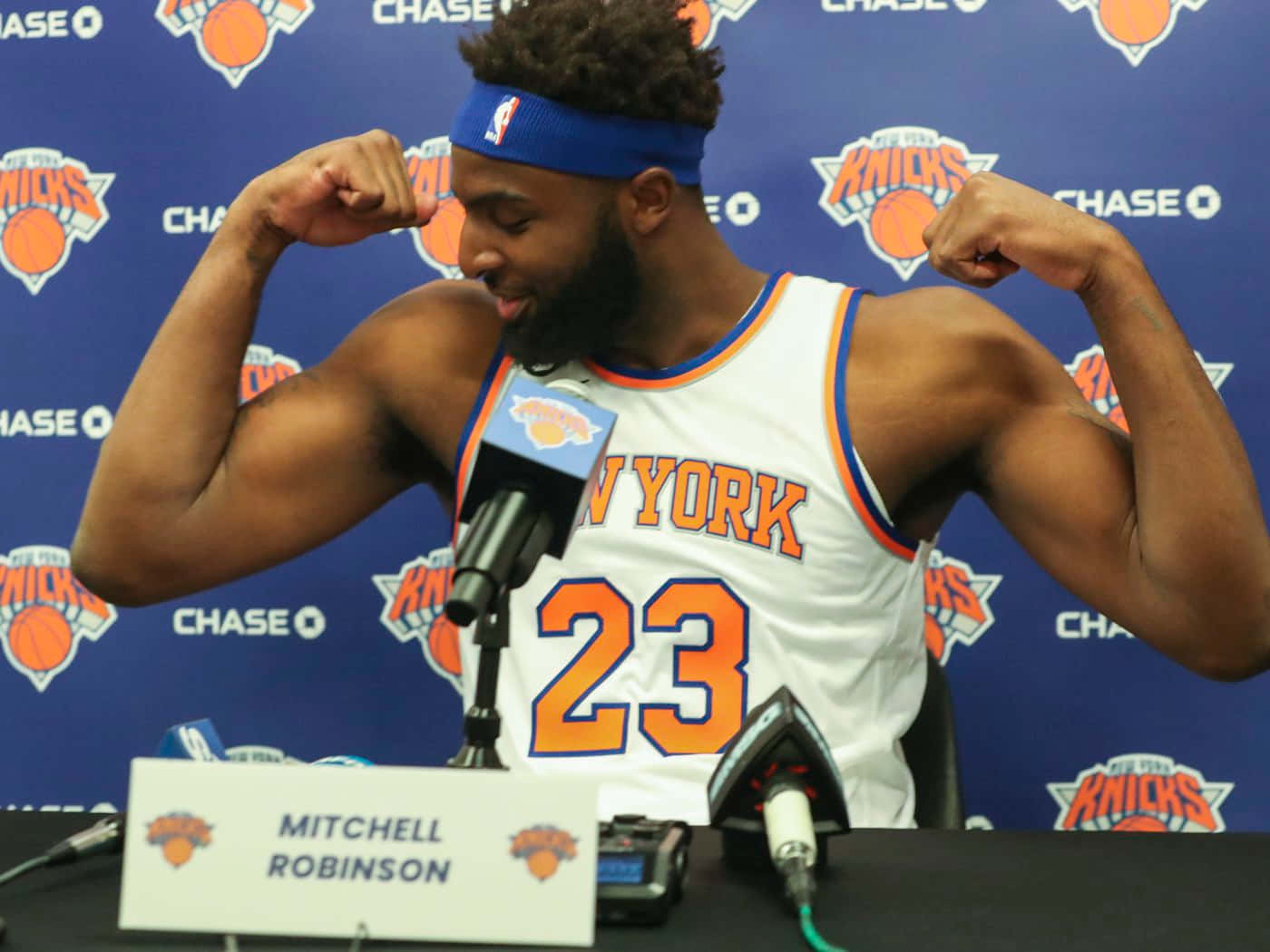 籃球運動員米切爾·羅賓遜在記者會上彎曲手臂。 — NBA 壁紙