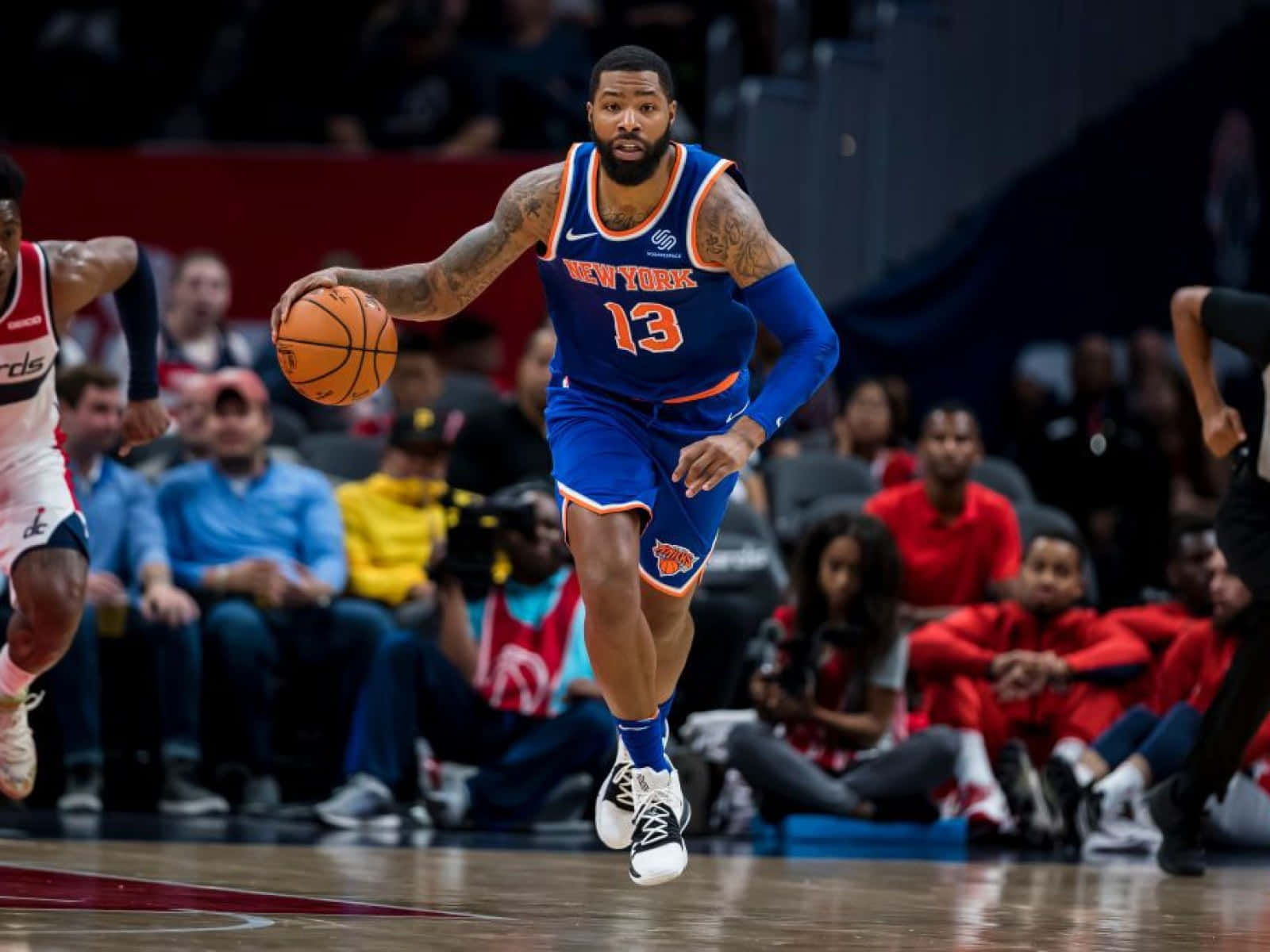 身穿藍色尼克球衣的籃球運動員在比賽中運球。 — NBA 壁紙