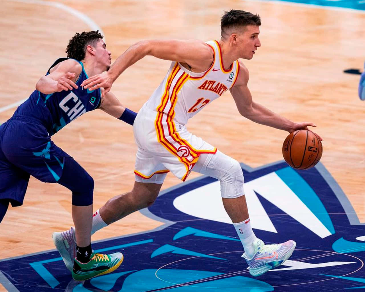 籃球運動員在比賽中運球越過防守球員。 — NBA 壁紙