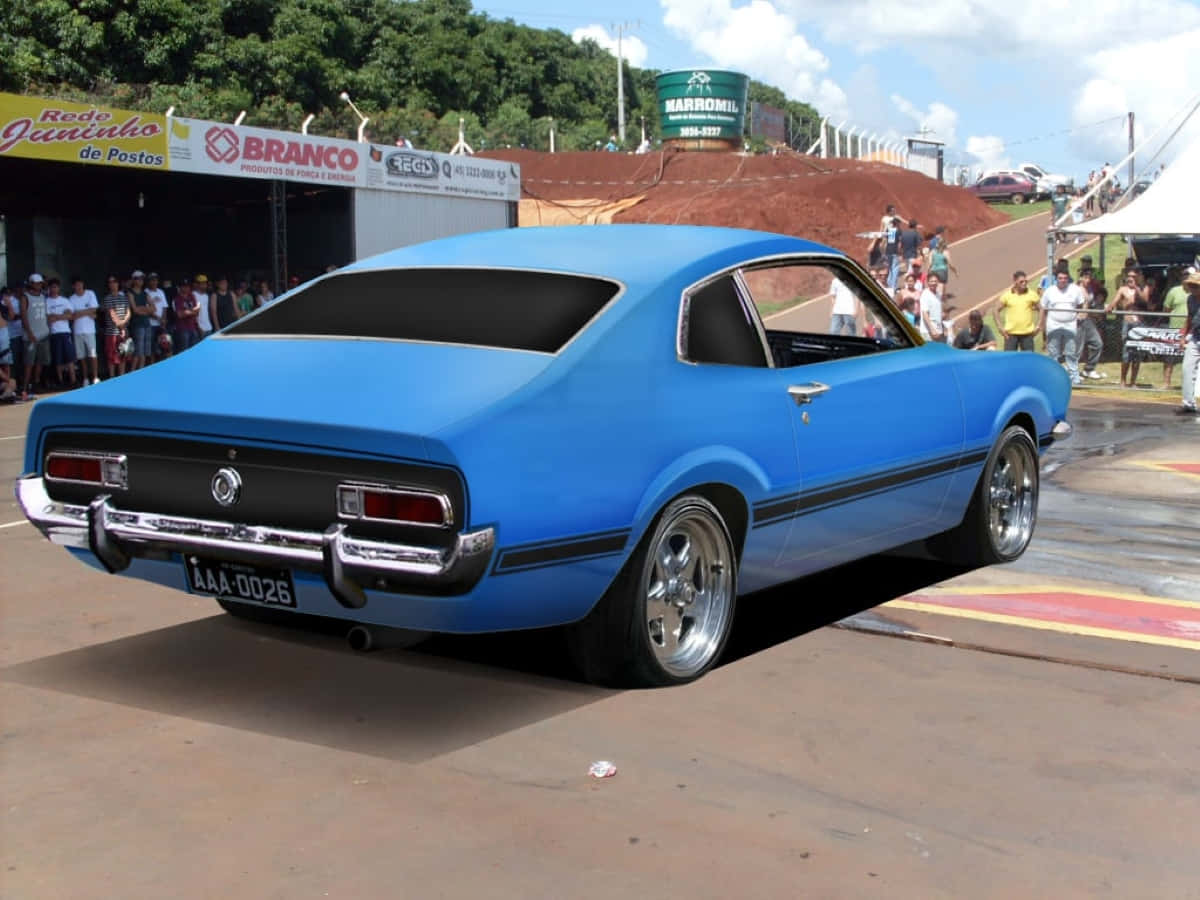 Ford Maverick 桌布 壁紙 — 一輛充滿活力的藍色經典肌肉車，配備鍍鉻輪圈，停放在陽光明媚的戶外車展上，周圍有觀眾。