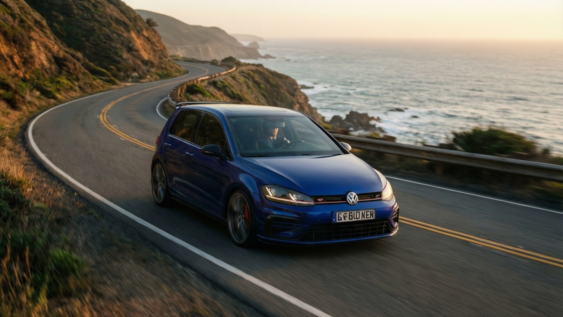 Coastal Drive R 壁紙 — 一輛充滿活力的藍色Volkswagen Golf R在日落時分沿著蜿蜒的海岸高速公路飛馳，下方海浪拍打。