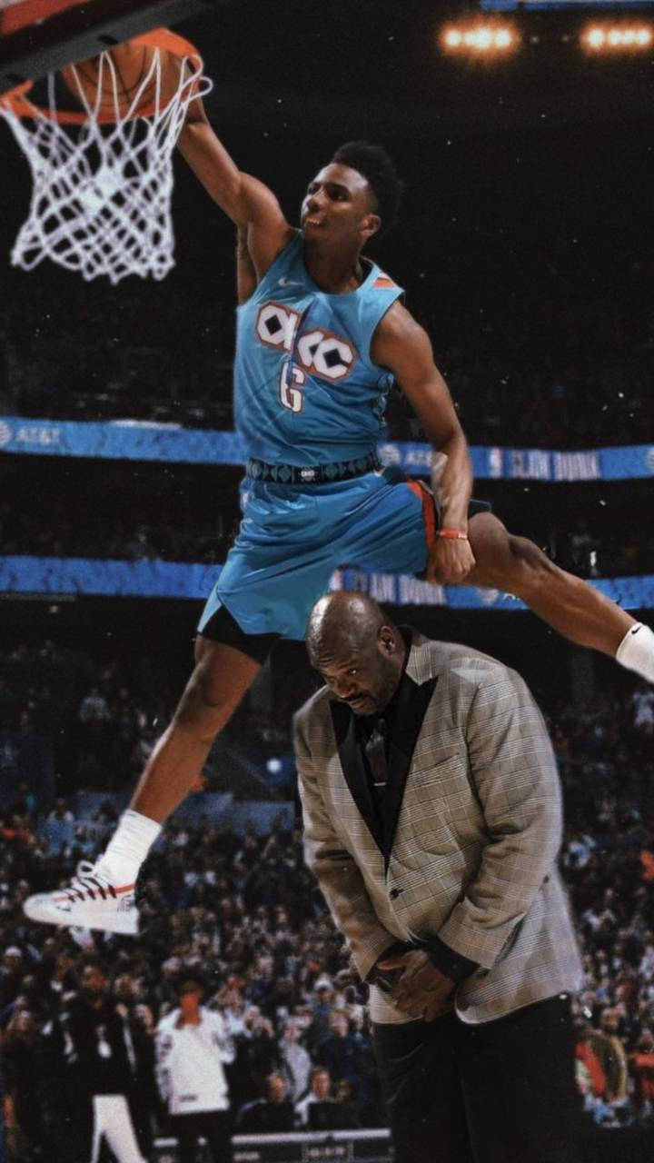 籃球運動員在比賽中扣籃越過穿西裝的男子。 — 酷 NBA 壁紙