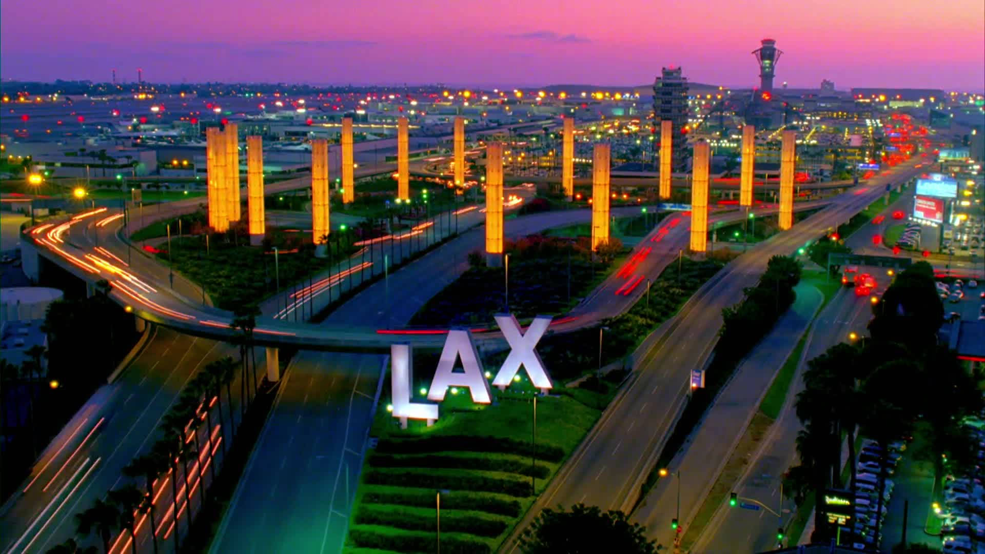 加州 桌布 壁紙 — LAX 在暮色中的鳥瞰圖，紫色天空下閃爍的橙色柱子和交通光跡。