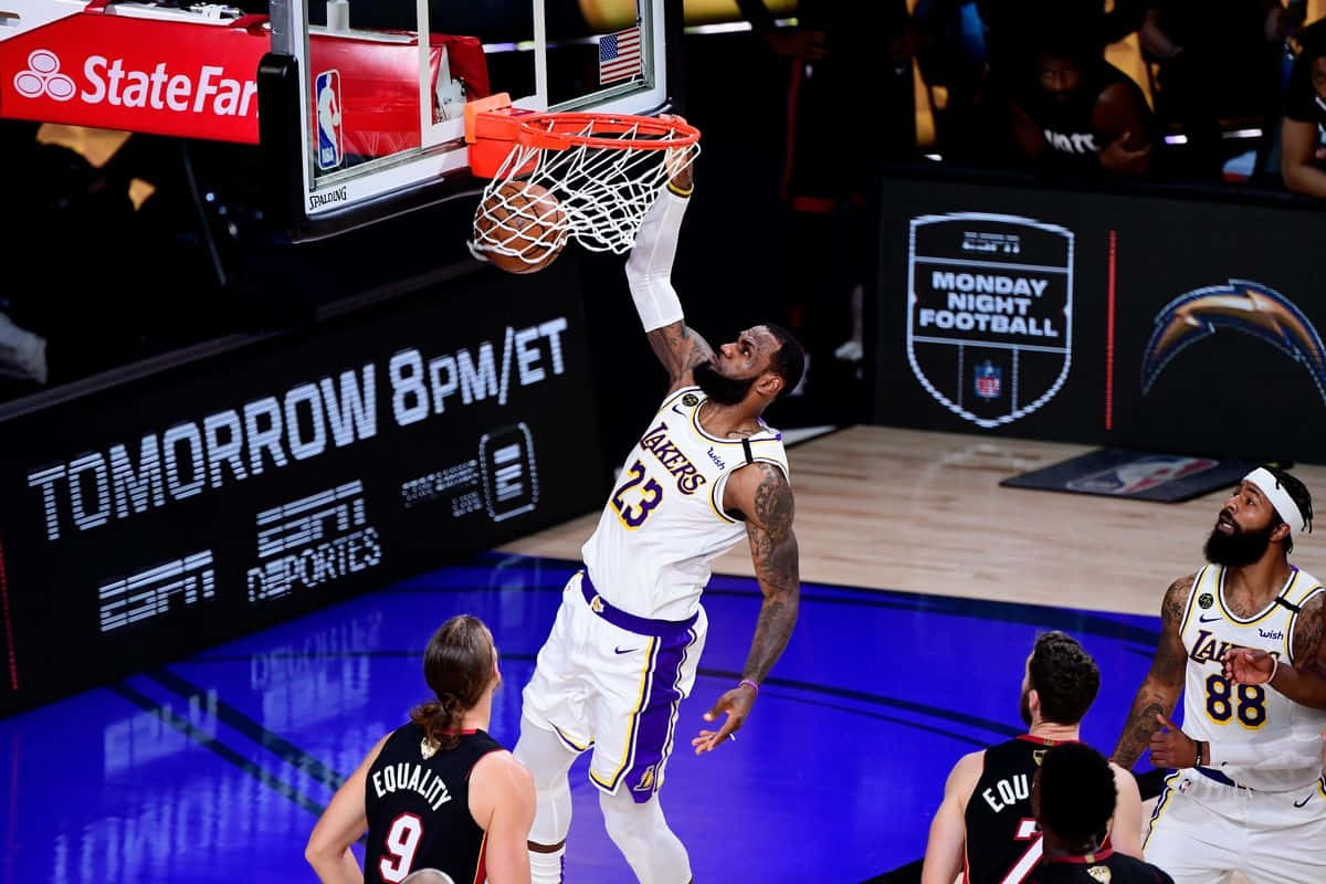  壁紙 — 勒布朗·詹姆斯在明亮的場館燈光下，穿著湖人球衣於激烈的NBA比賽中灌籃。