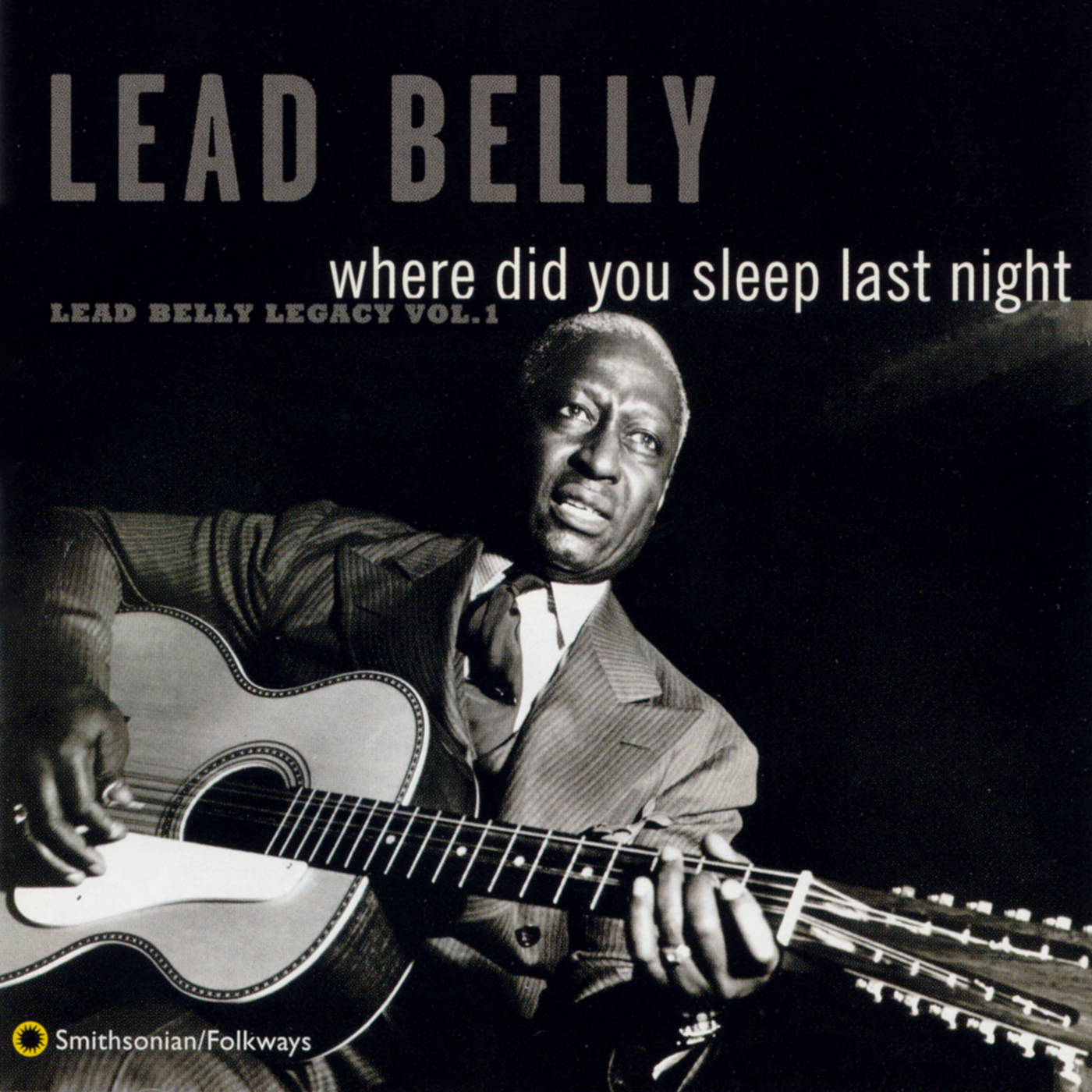Album Cover 桌布 壁紙 — Lead Belly 在黑暗背景下手持原聲吉他的戲劇性黑白肖像。