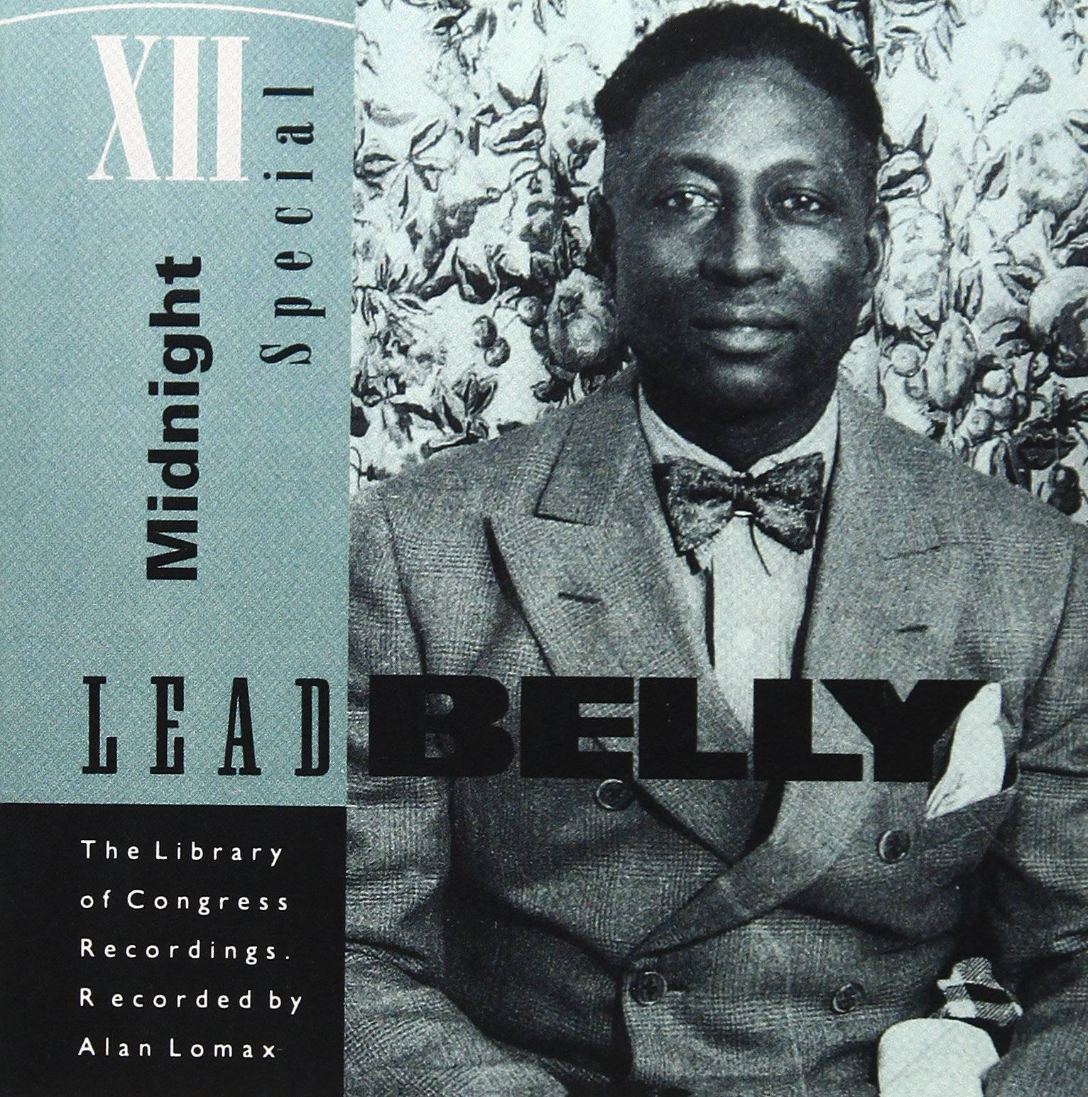 復古 桌布 壁紙 — Lead Belly 穿著西裝和領結，以花卉壁紙背景為襯托的復古黑白肖像。