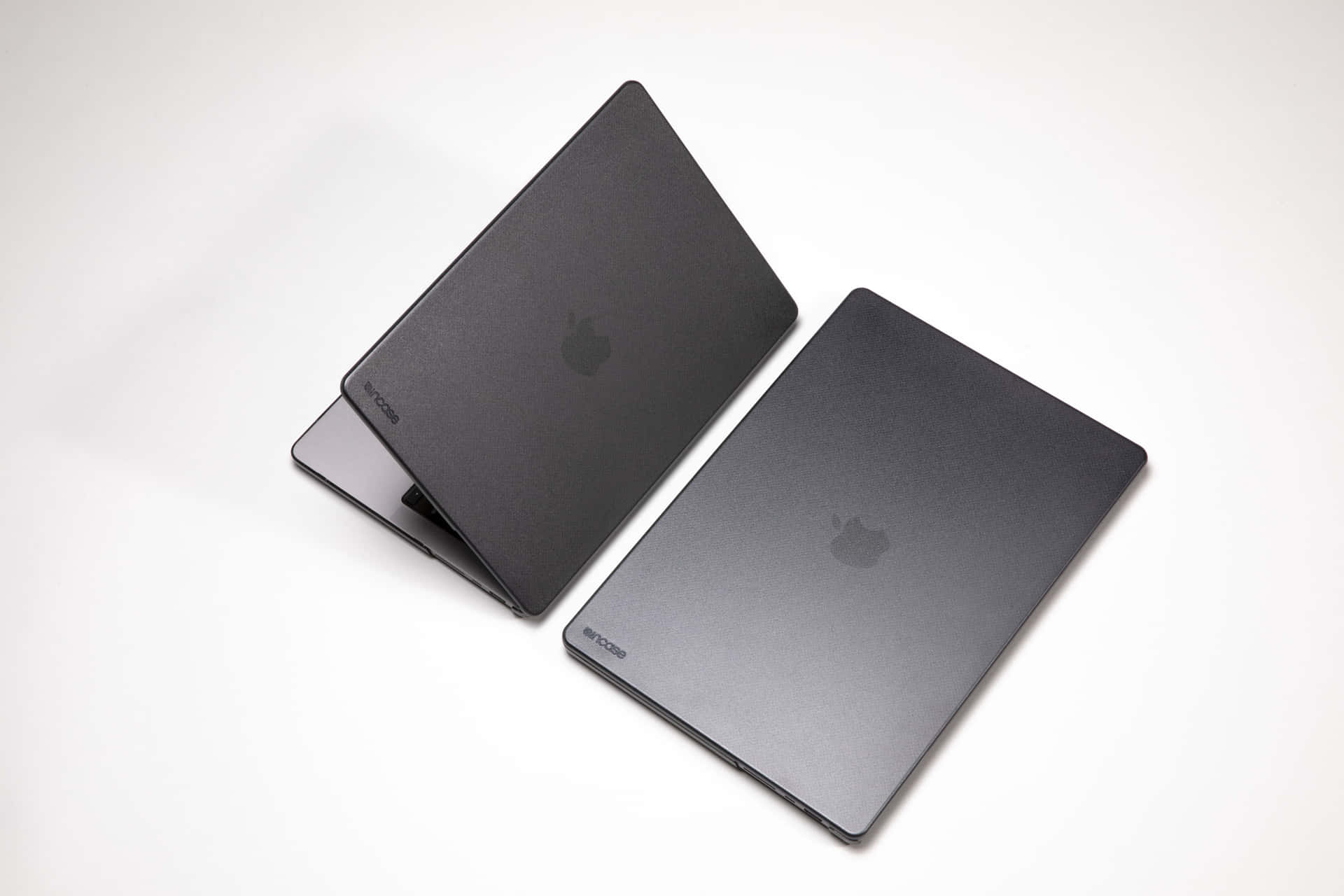 白色背景上的兩部黑色MacBook筆記型電腦 — Macbook Pro 壁紙