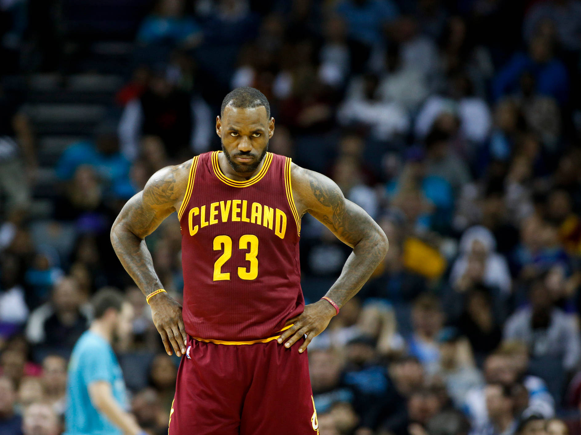 勒布朗·詹姆斯身穿克里夫蘭球衣，在比賽中雙手叉腰站立。 — NBA 壁紙
