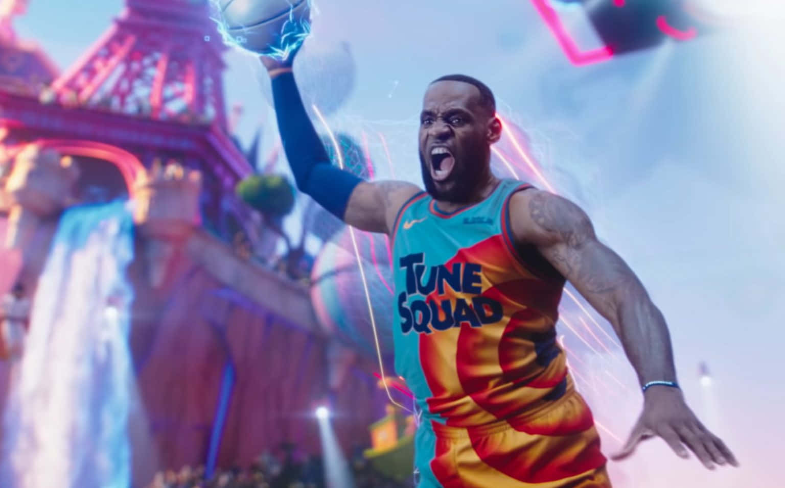 勒布朗·詹姆斯 桌布 壁紙 — LeBron James身穿鮮豔的Tune Squad球衣，手持發光的籃球，在霓虹燈照耀的巴黎天際線前勝利躍起。