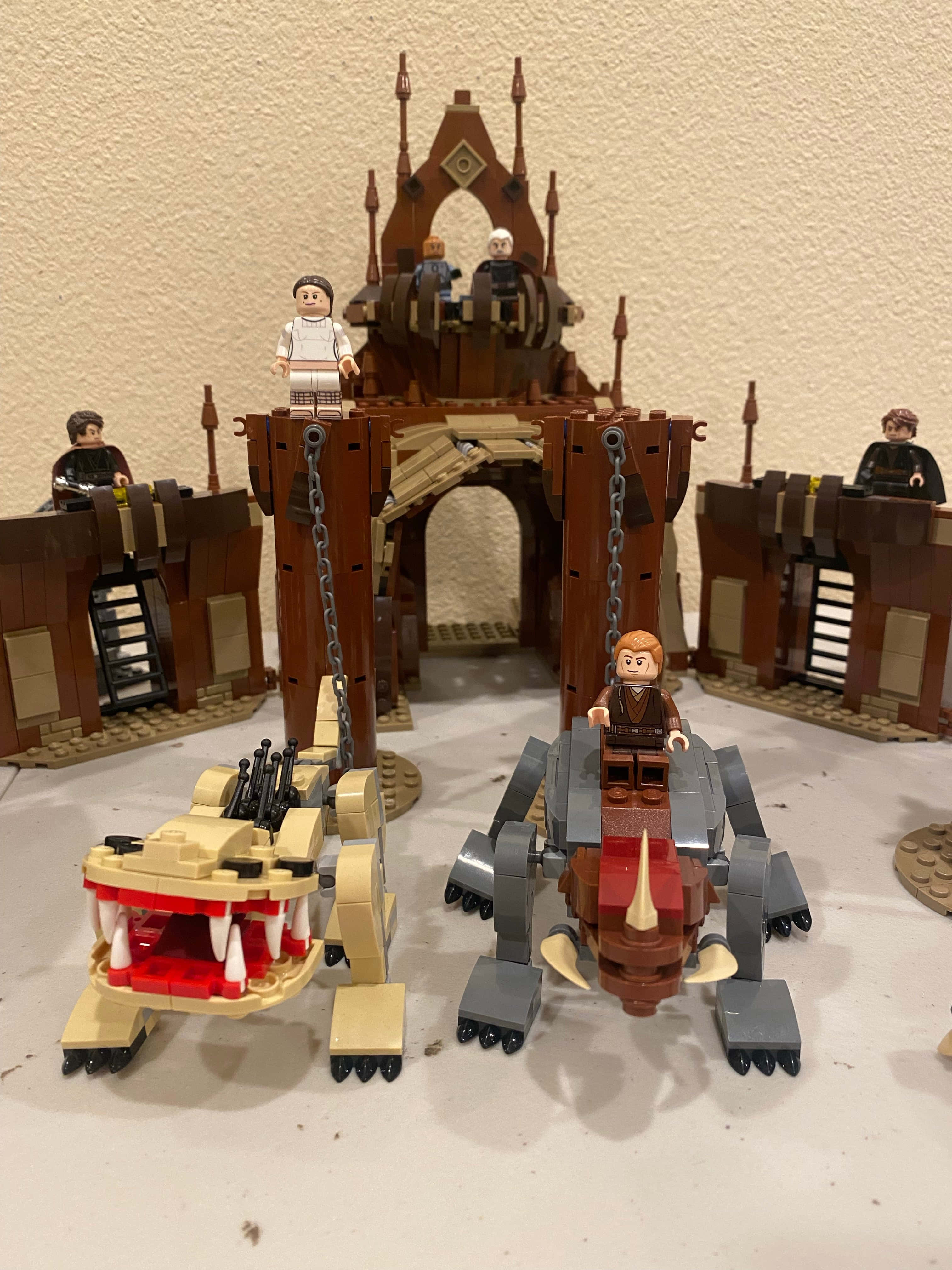 The Geonosian Arena 桌布 壁紙 — LEGO Star Wars 城堡連同人偶及兩部詳細的飛梭賽車，放置在平坦表面上。