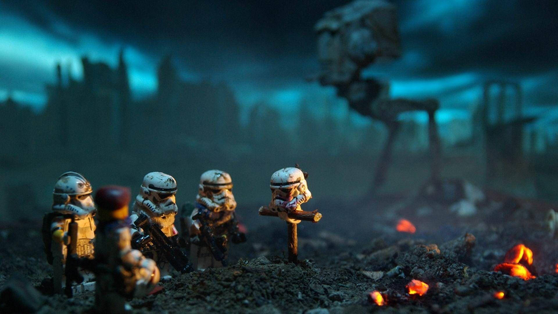 Stormtrooper 桌布 壁紙 — LEGO 風暴兵在毀滅的戰場上莊嚴地站立，天空是暴風雨的藍色，有發光的餘燼和遠處的 AT-AT 步行機。