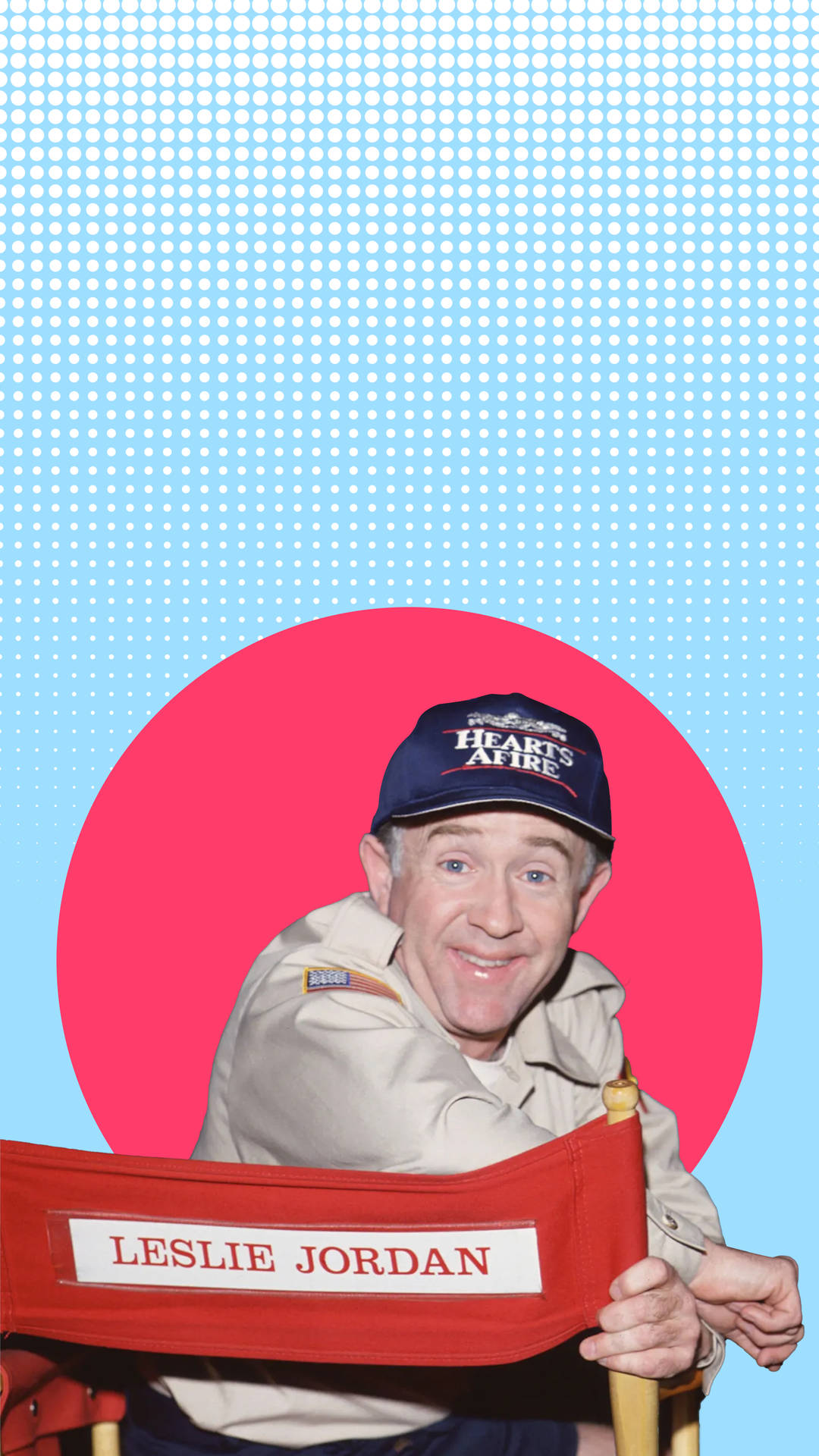 Leslie Jordan 在導演椅上，背景有粉紅色圓圈和藍色半色調。 — Michael B Jordan 壁紙