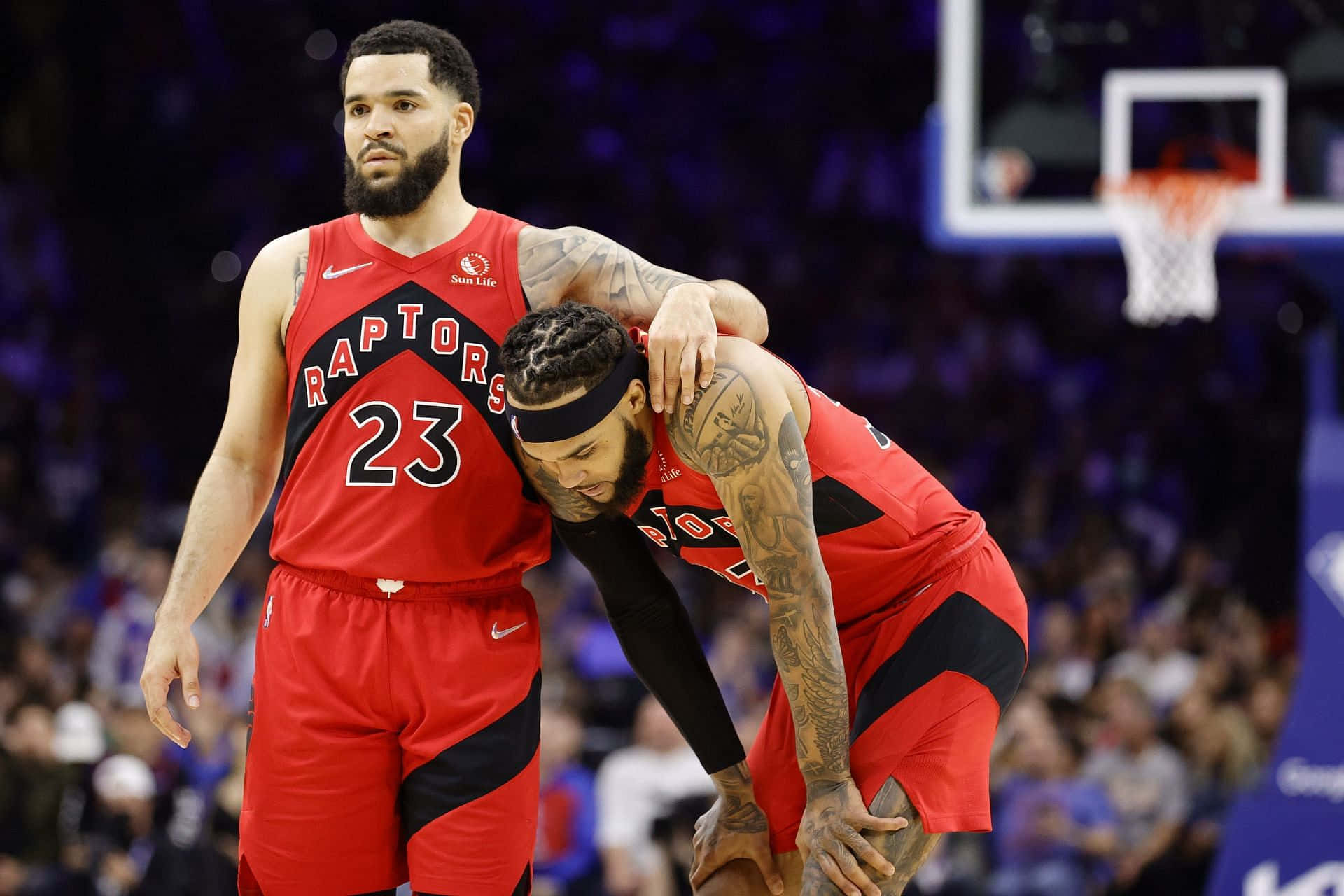 兩名多倫多暴龍籃球球員在比賽中於球場上擁抱。 — NBA 壁紙