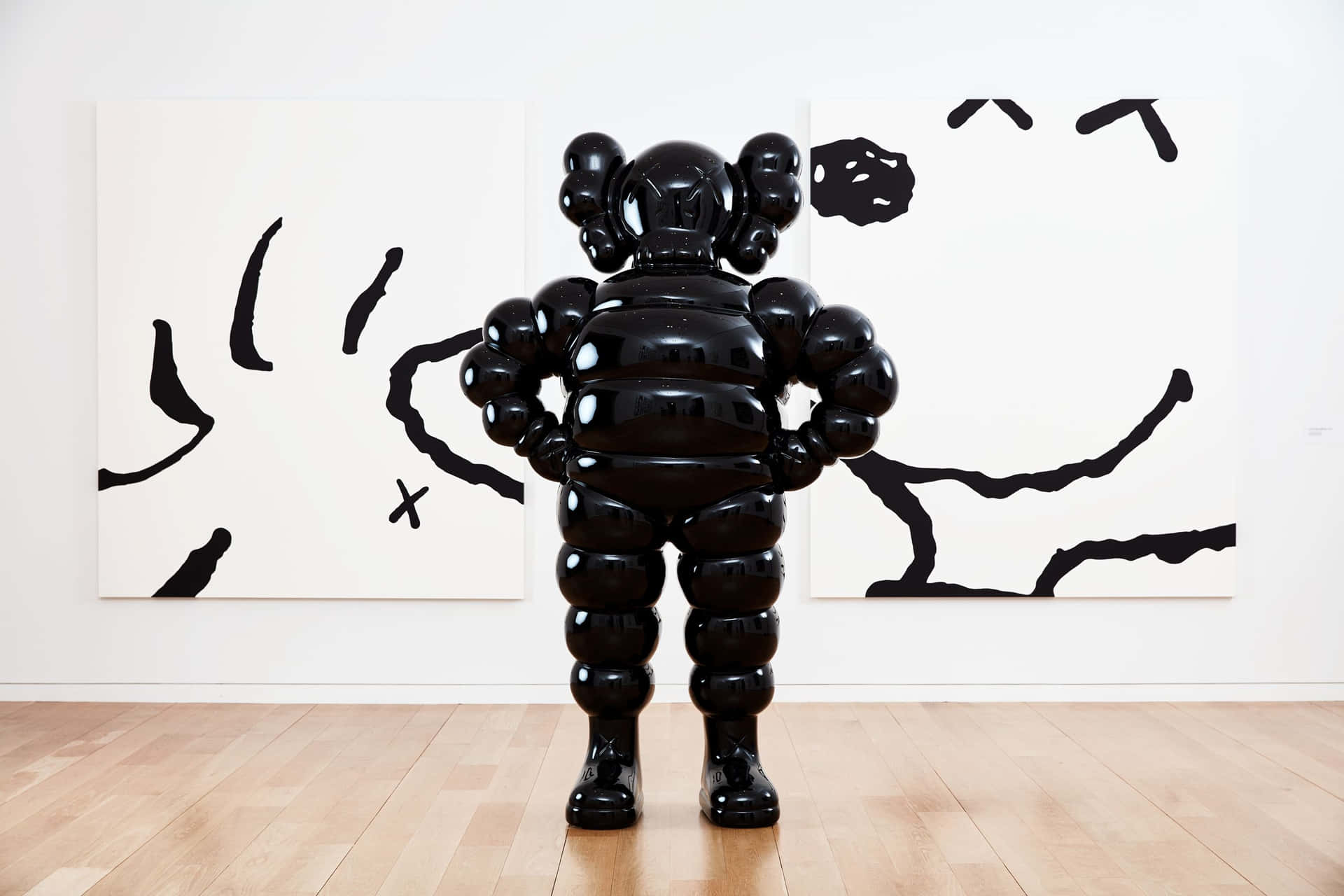 畫廊中帶有抽象藝術的黑色KAWS雕塑 — Kaws 壁紙