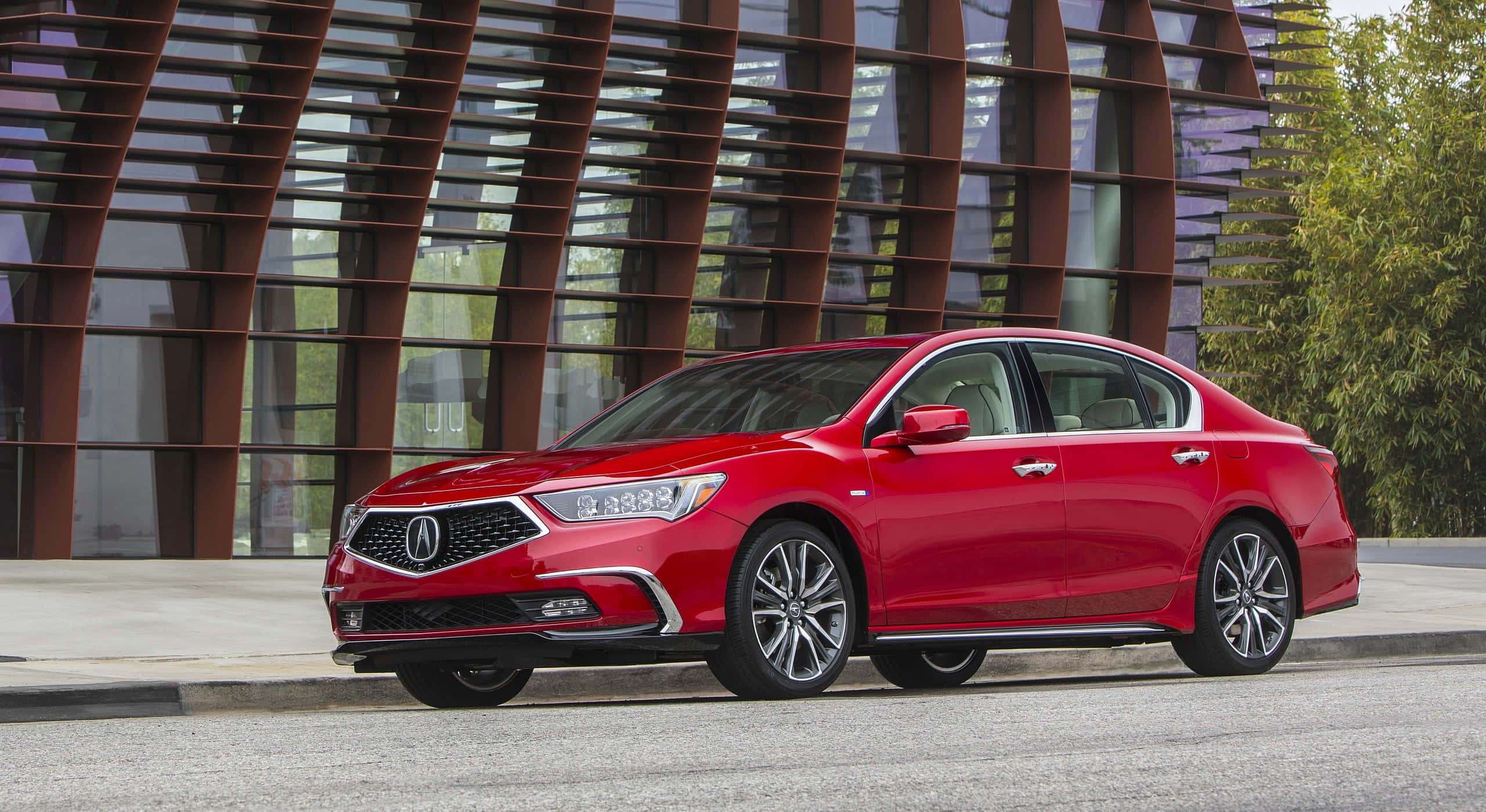 Acura Rlx 桌布 壁紙 — 一輛亮紅色的Acura轎車停在一棟採用彎曲金屬和玻璃建築風格的現代建築前。