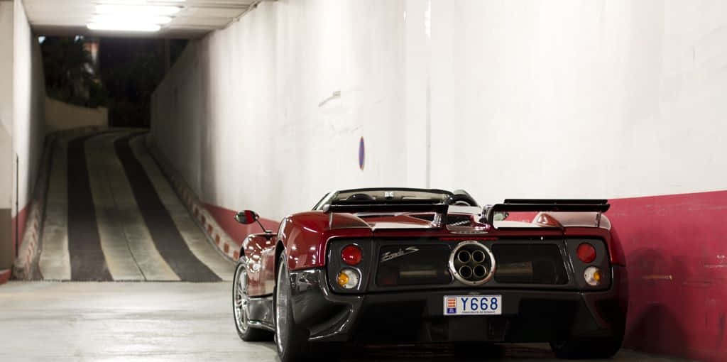 Pagani Zonda C12 Roadster 桌布 壁紙 — 一輛亮紅色法拉利F430 Spider停放在燈光昏暗、帶有條紋坡道的地下停車場。