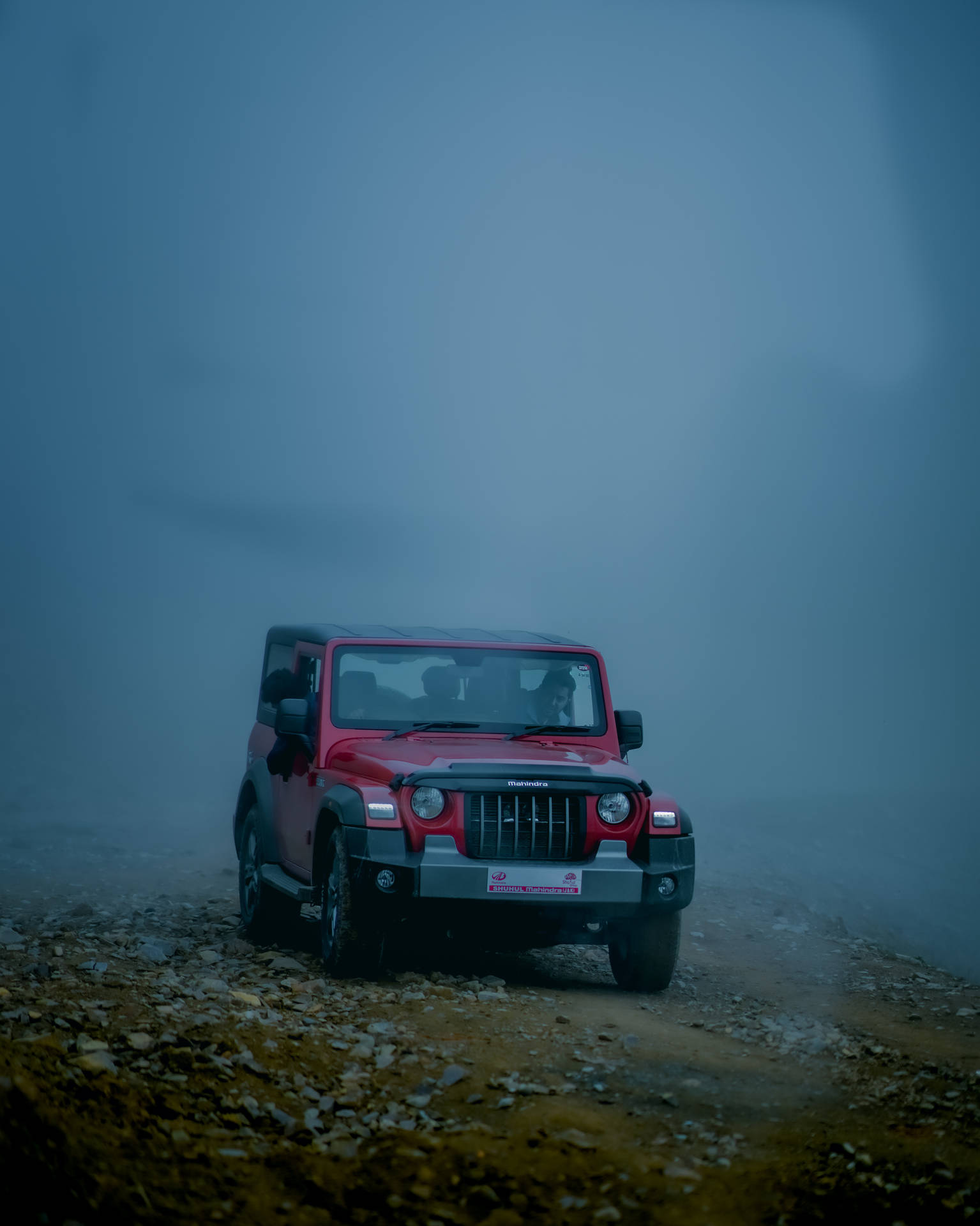 紅色Jeep Wrangler在黃昏時分穿過霧氣瀰漫的山區地形。 — 汽車 4K 壁紙