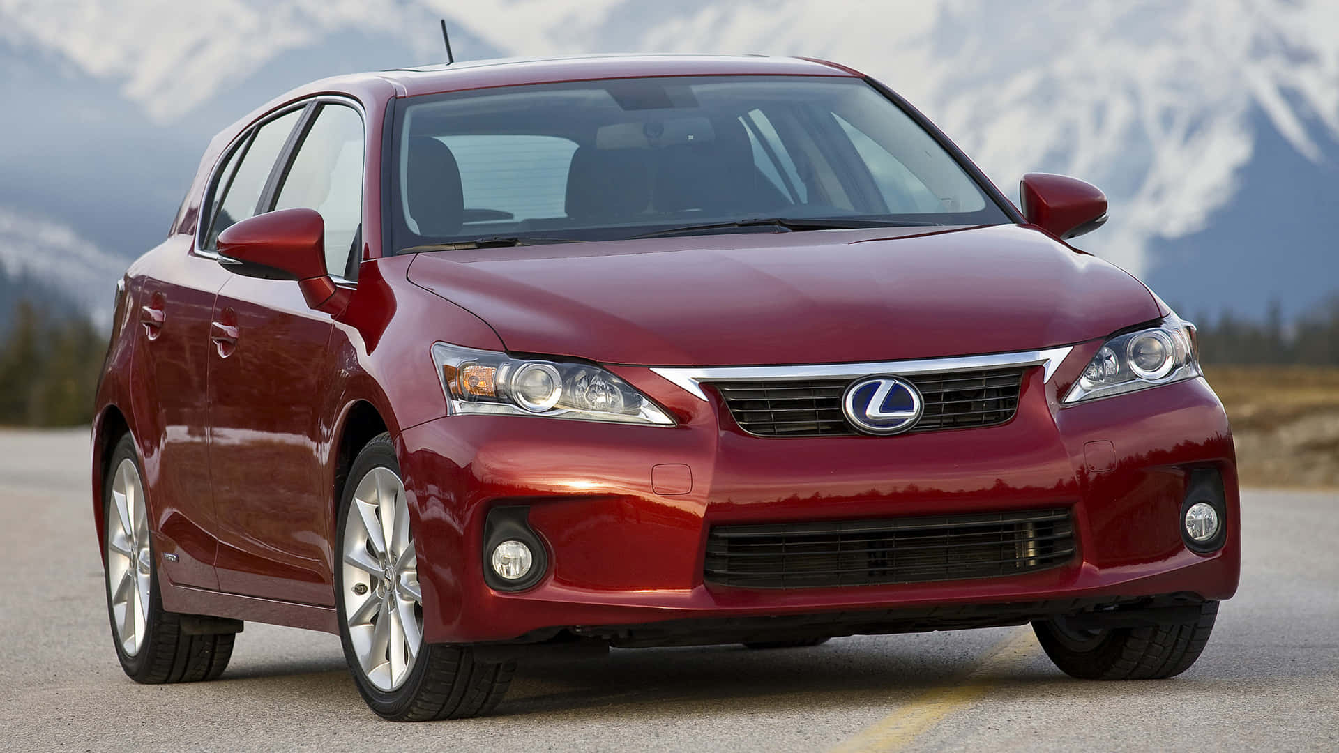 Lexus Ct 200h 桌布 壁紙 — 一輛亮紅色的Lexus CT 200h混合動力掀背車停在道路上，背景是白雪覆蓋的山脈。