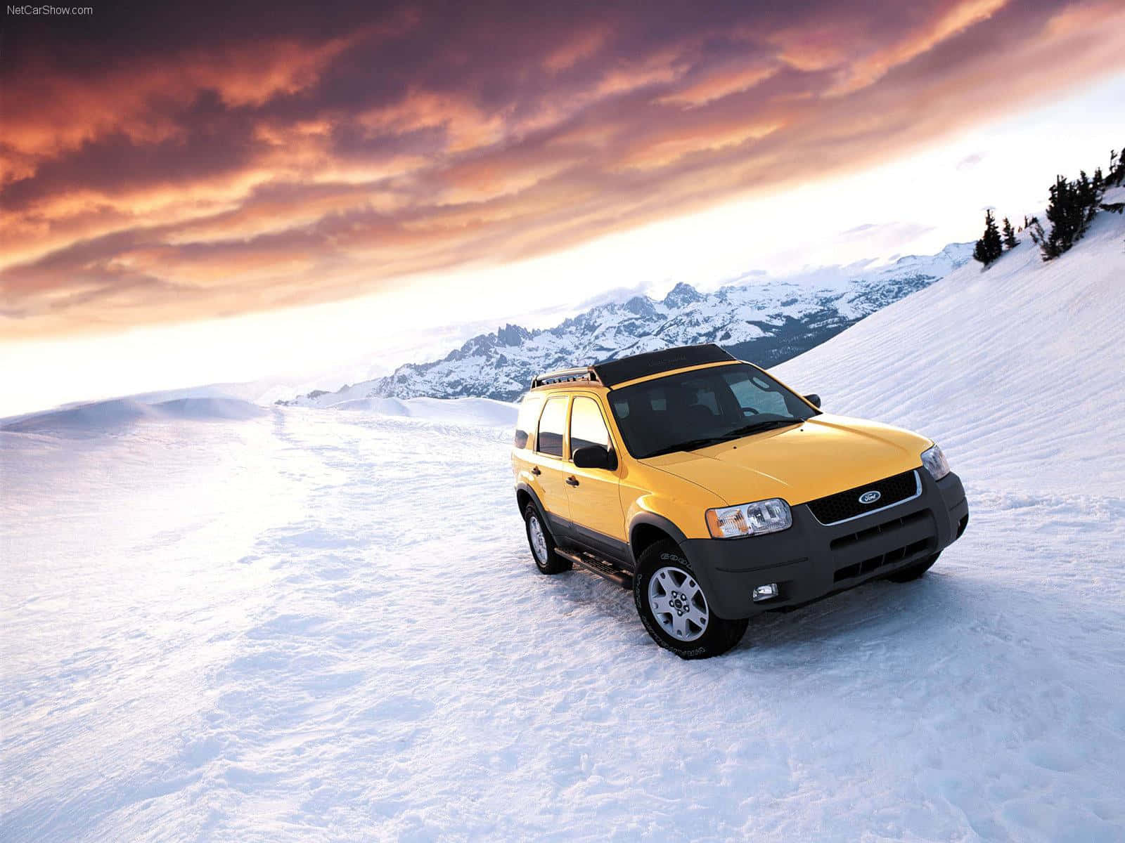 Ford Escape 桌布 壁紙 — 一輛亮黃色SUV獨自停在一片廣闊的雪原上，背景是戲劇性的橙紫色日落天空和遠處的雪山。