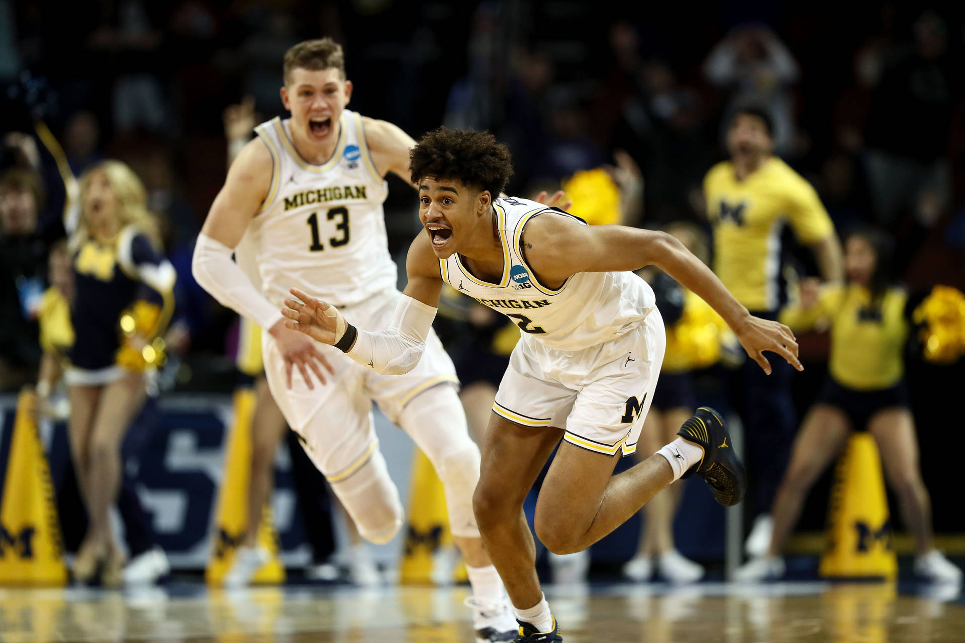 密西根大學籃球運動員在比賽中慶祝一次進攻。 — Jordan Poole 壁紙