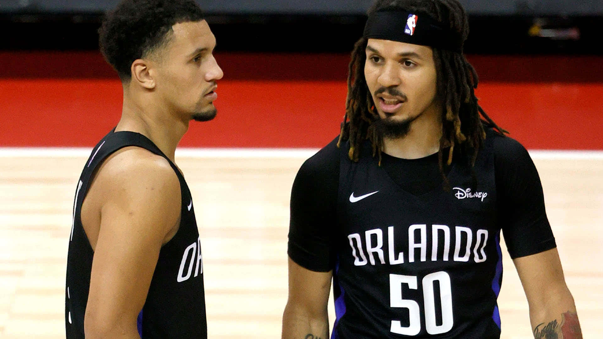 兩名奧蘭多魔術籃球運動員在球場上交談。 — NBA 壁紙