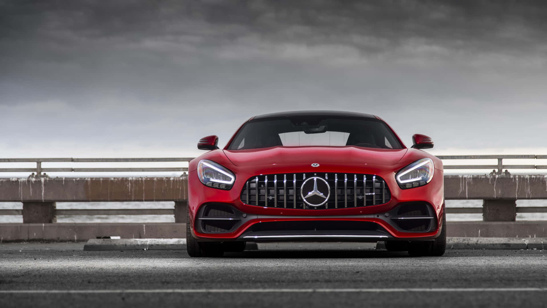 暴風雨天空下，濕滑橋上的紅色 Mercedes-AMG GT 跑車。 — 4K 奔馳壁紙 壁紙