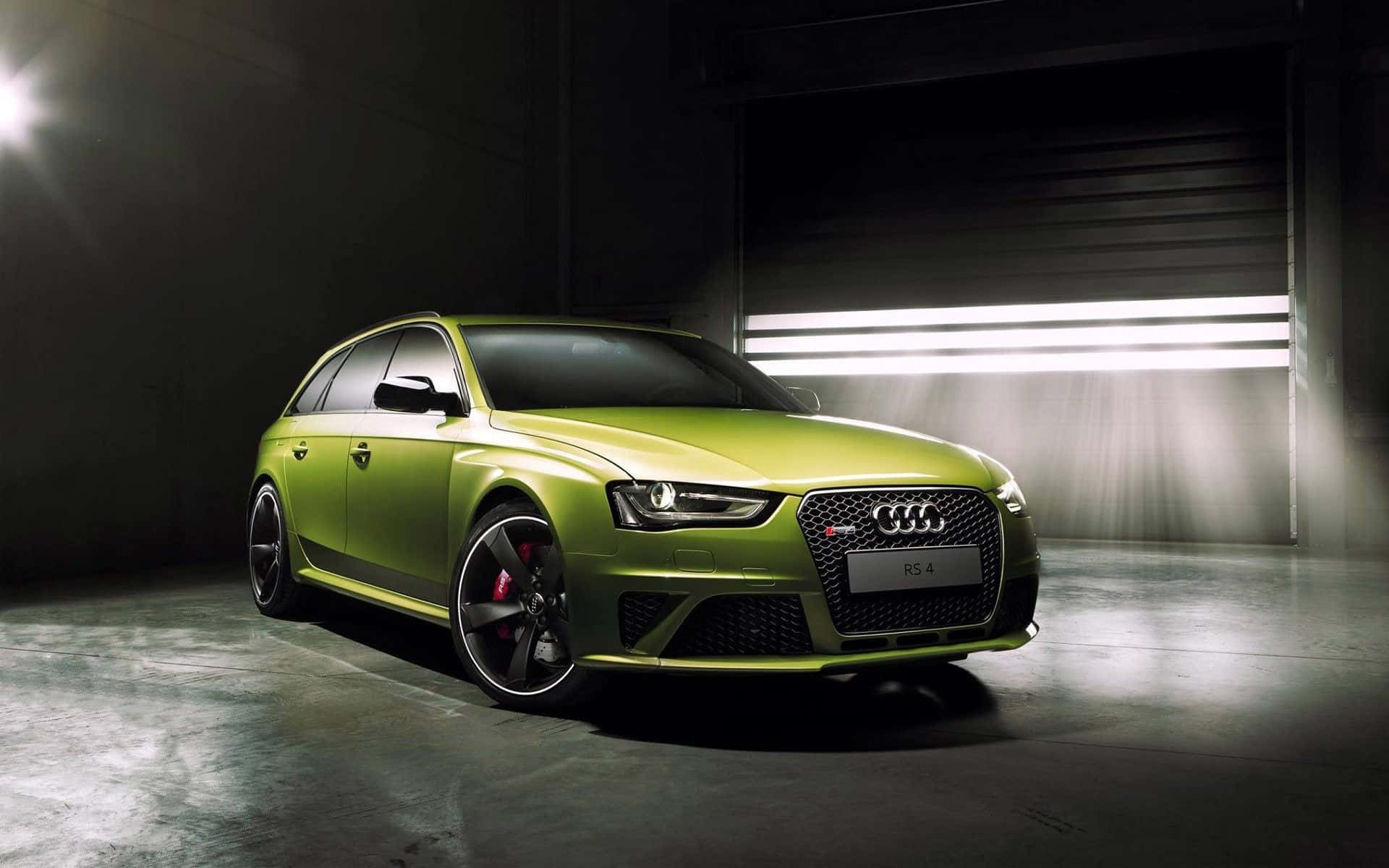 Audi Rs4 桌布 壁紙 — 一輛充滿活力的青檸綠色奧迪RS4旅行車在黑暗的工業車庫中，在戲劇性的工作室燈光下閃閃發光。