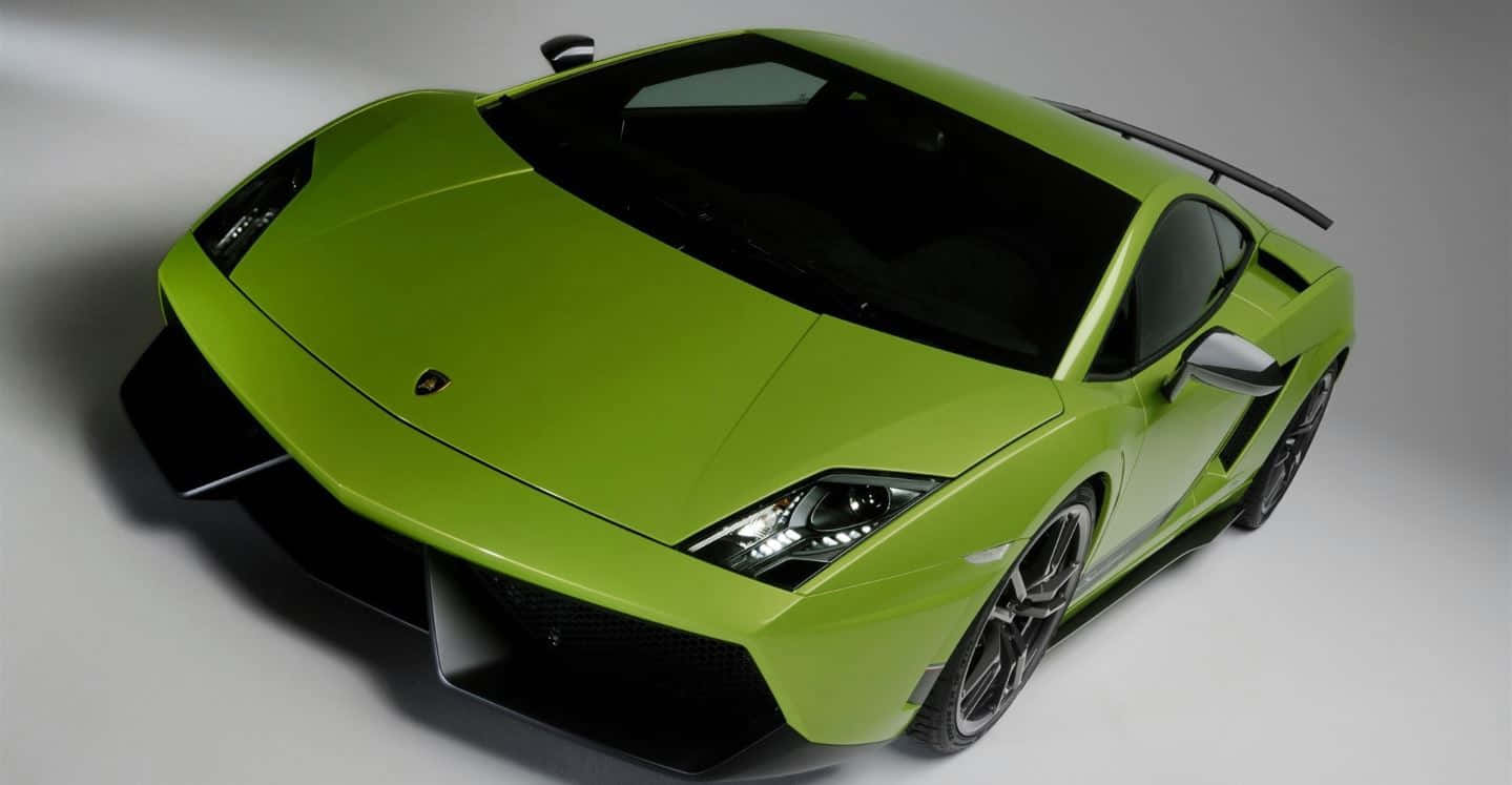 Lamborghini Gallardo 桌布 壁紙 — 一輛充滿活力的萊姆綠色藍寶堅尼跑車，帶有黑色飾邊和流線型空氣動力學設計，在攝影棚內拍攝。