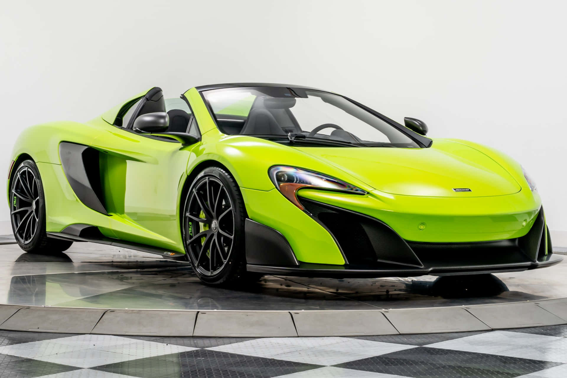 Mclaren 675lt Spider 桌布 壁紙 — 一輛充滿活力的青檸綠色McLaren跑車，帶有黑色飾邊和敞篷車頂，在白色背景的棋盤格地板上展示。