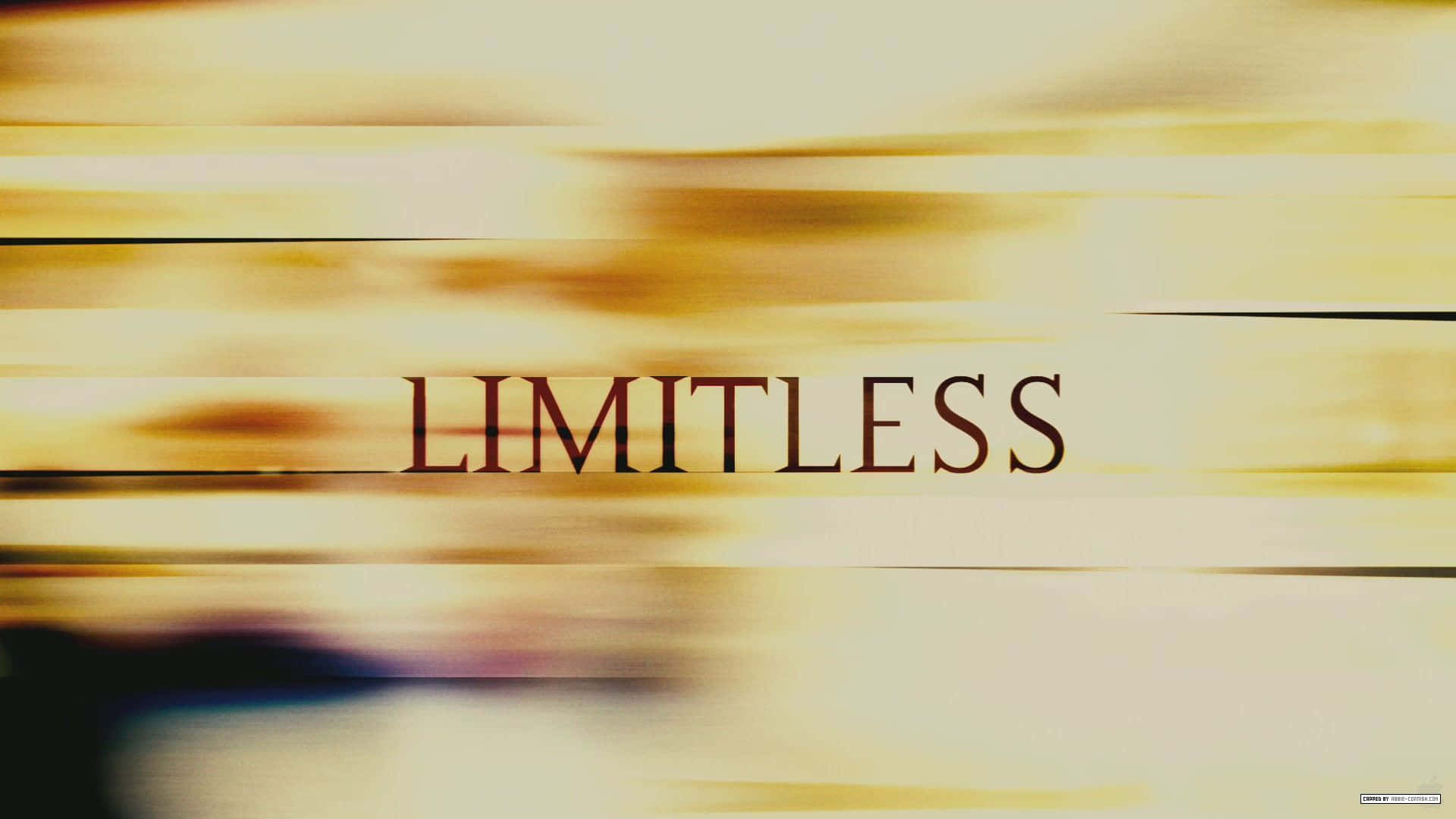 Word 桌布 壁紙 — 「limitless」一詞以粗體襯線字體在帶有動態模糊的金色抽象條紋背景上發光。