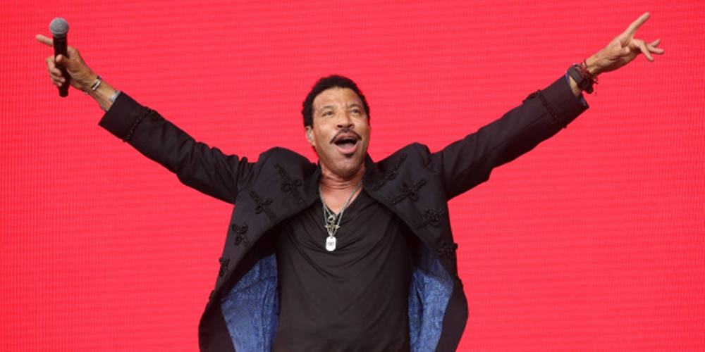 Singing 桌布 壁紙 — Lionel Richie 在充滿活力的紅色LED背景前，張開雙臂充滿活力地在舞台上表演。