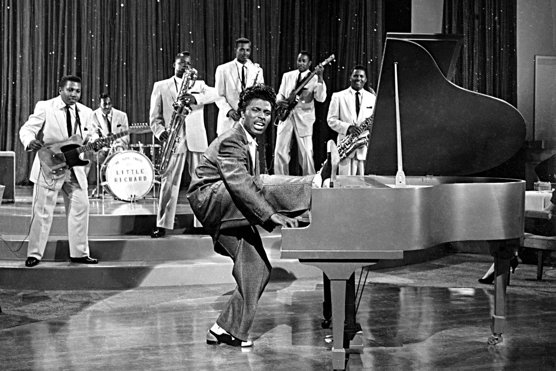 黑白 桌布 壁紙 — Little Richard 在黑白照片中充滿活力地在舞台上表演，他的樂隊在他身後。