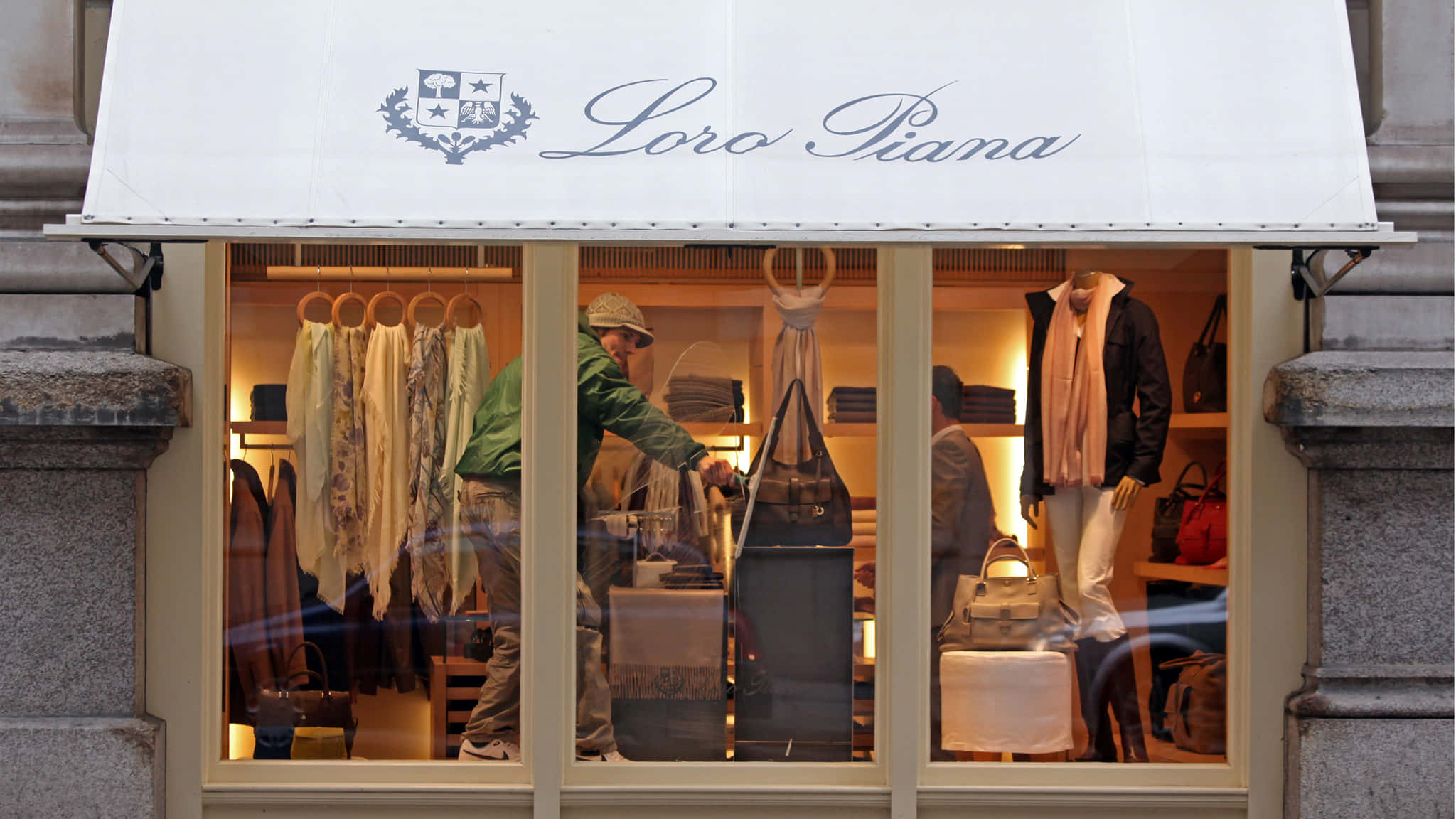 筆電 桌布 壁紙 — Loro Piana 精品店櫥窗展示奢華圍巾、手提包和模特兒，店員在內整理商品。