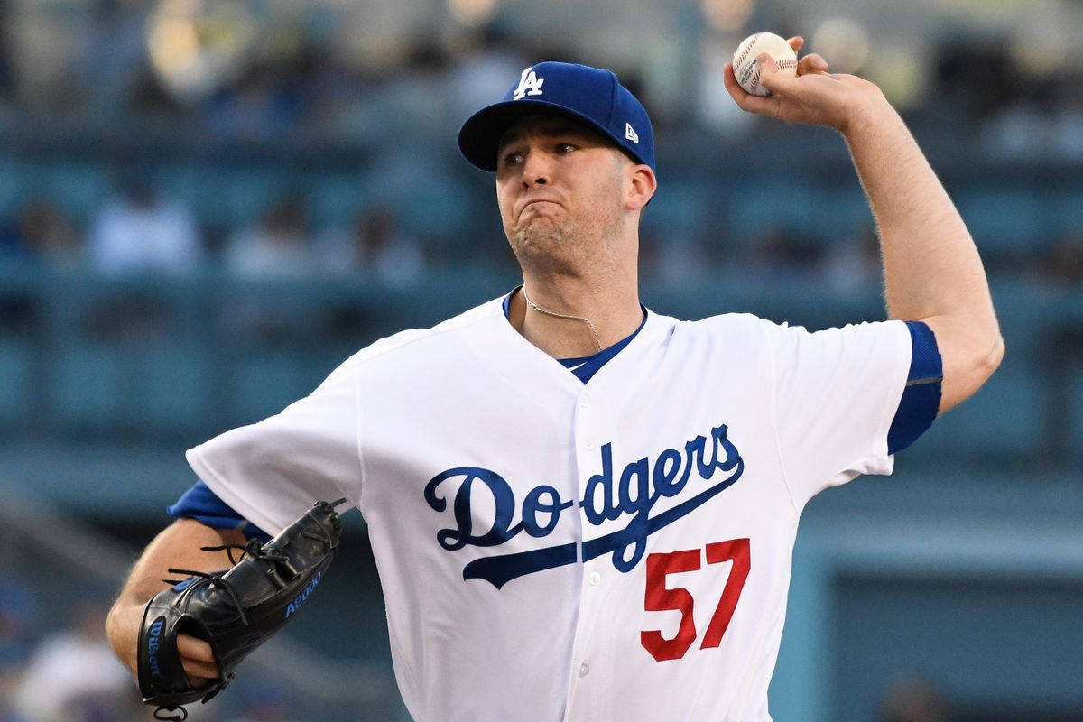 身穿道奇隊球衣的棒球投手在夜間準備投球。 — MLB 壁紙