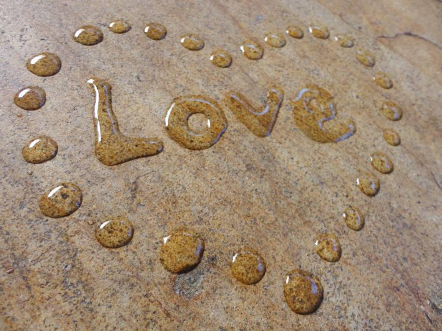 Really Cool Love 桌布 壁紙 — 「love」這個字用帶有紋理的石頭表面上的水滴拼成，周圍還有珠子做的心形輪廓。