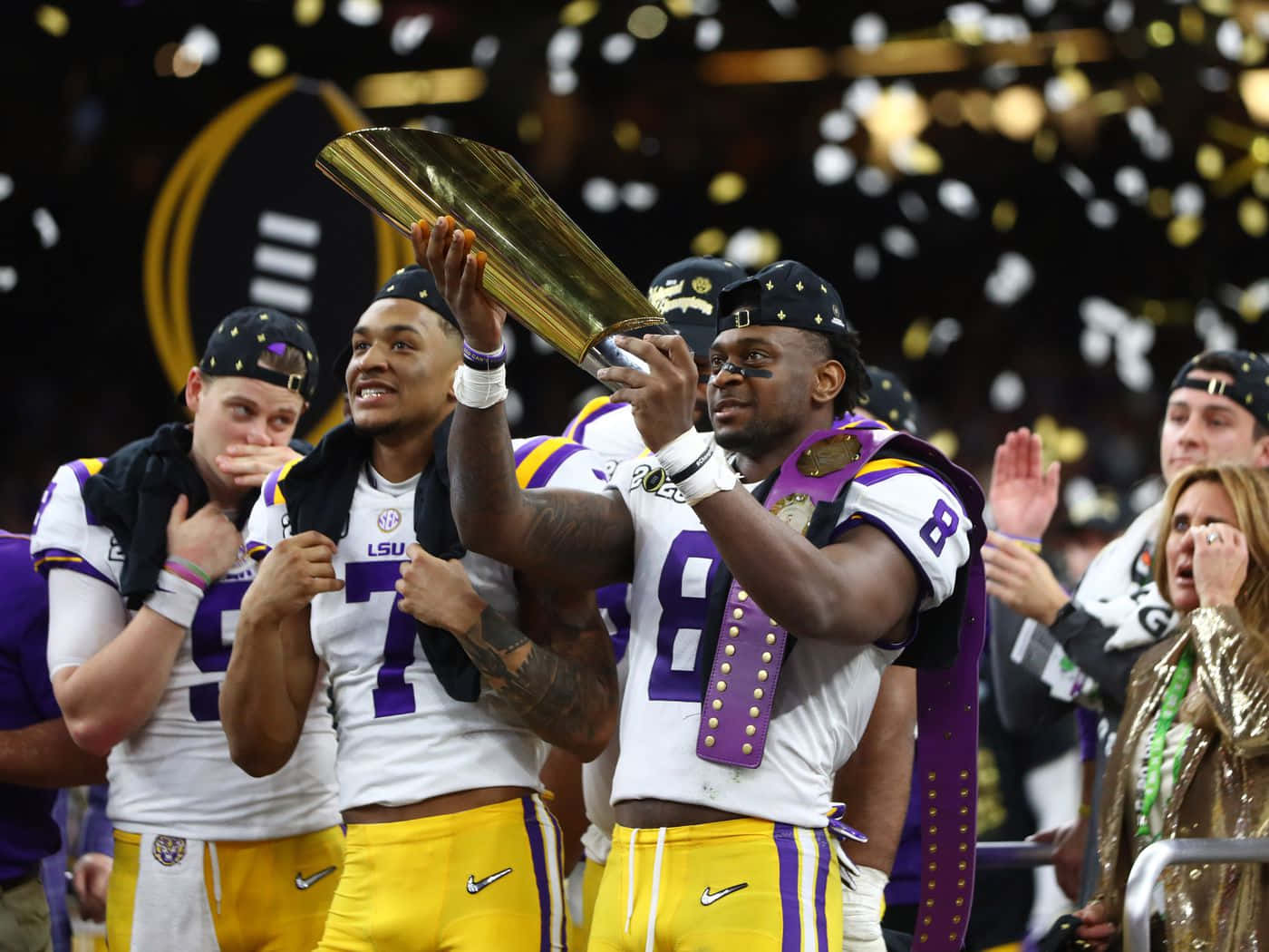  壁紙 — LSU 足球員手持閃亮獎盃慶祝勝利，金色紙屑如雨般灑落球場。