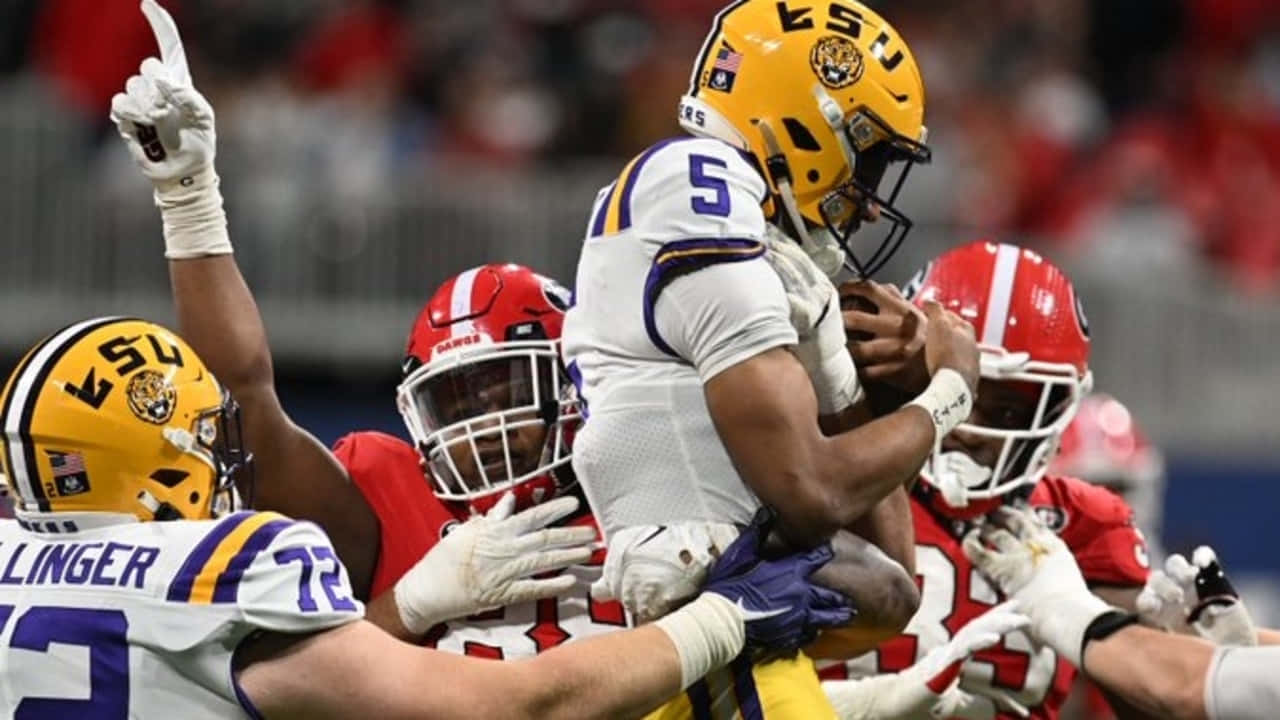  壁紙 — LSU 足球員在體育館人群中慶祝達陣，其中一名球員被隊友抬起。