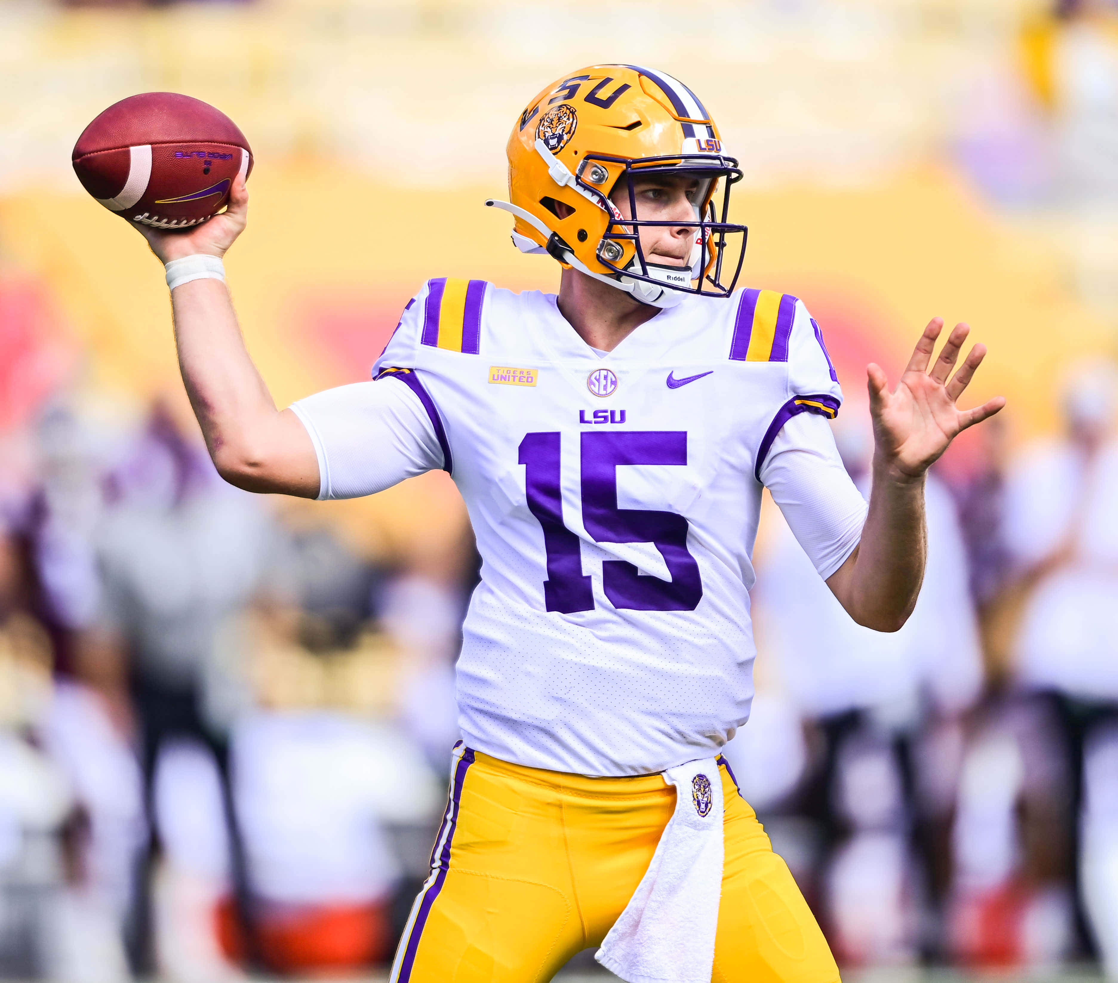 Athletic 桌布 壁紙 — LSU 美式足球四分衛15號身穿白色和金色球衣，在比賽中準備投球。
