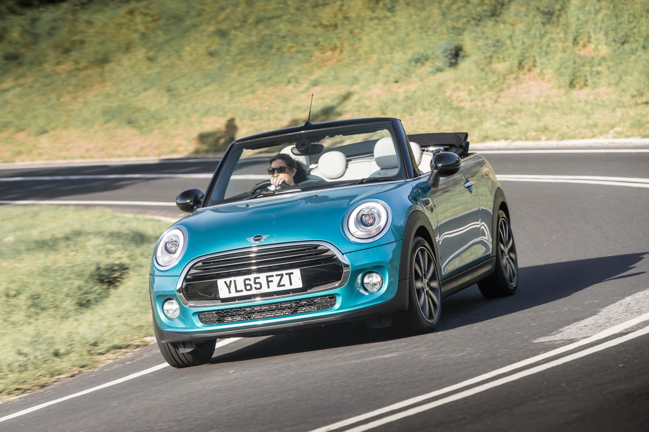 Mini Cooper S Convertible 桌布 壁紙 — 一輛綠松色的MINI Convertible沿著蜿蜒的道路疾馳，司機在明亮的陽光下享受敞篷駕駛。