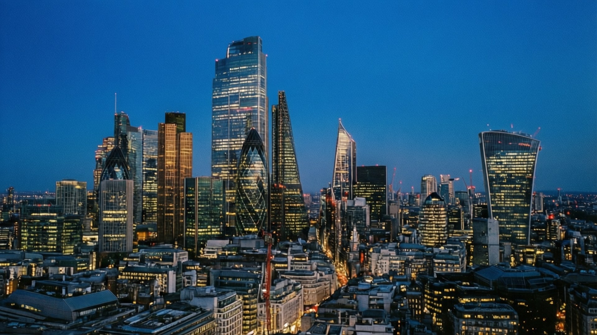 City of London Blue Hour 壁紙 — 倫敦天際線在黃昏時分，摩天大樓在深藍色天空的映襯下燈火通明。