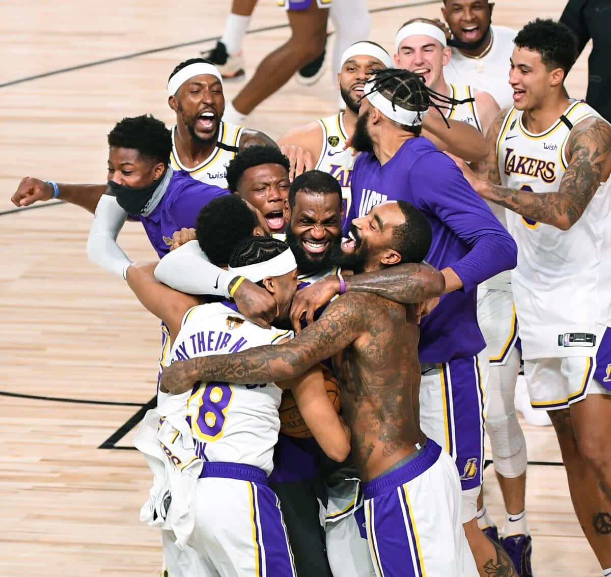  壁紙 — 洛杉磯湖人籃球運動員在比賽獲勝後，在球場上爆發出混亂而歡樂的堆疊。