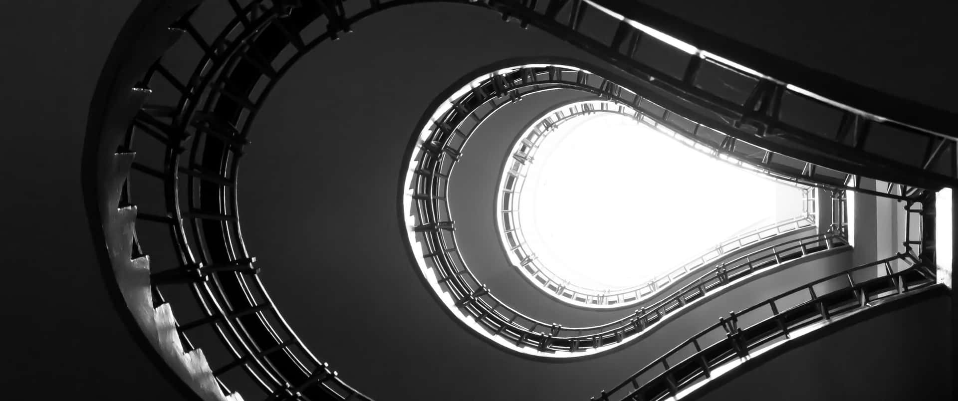 現代建築中通往明亮天窗的螺旋樓梯。 — 3440X1440 壁紙