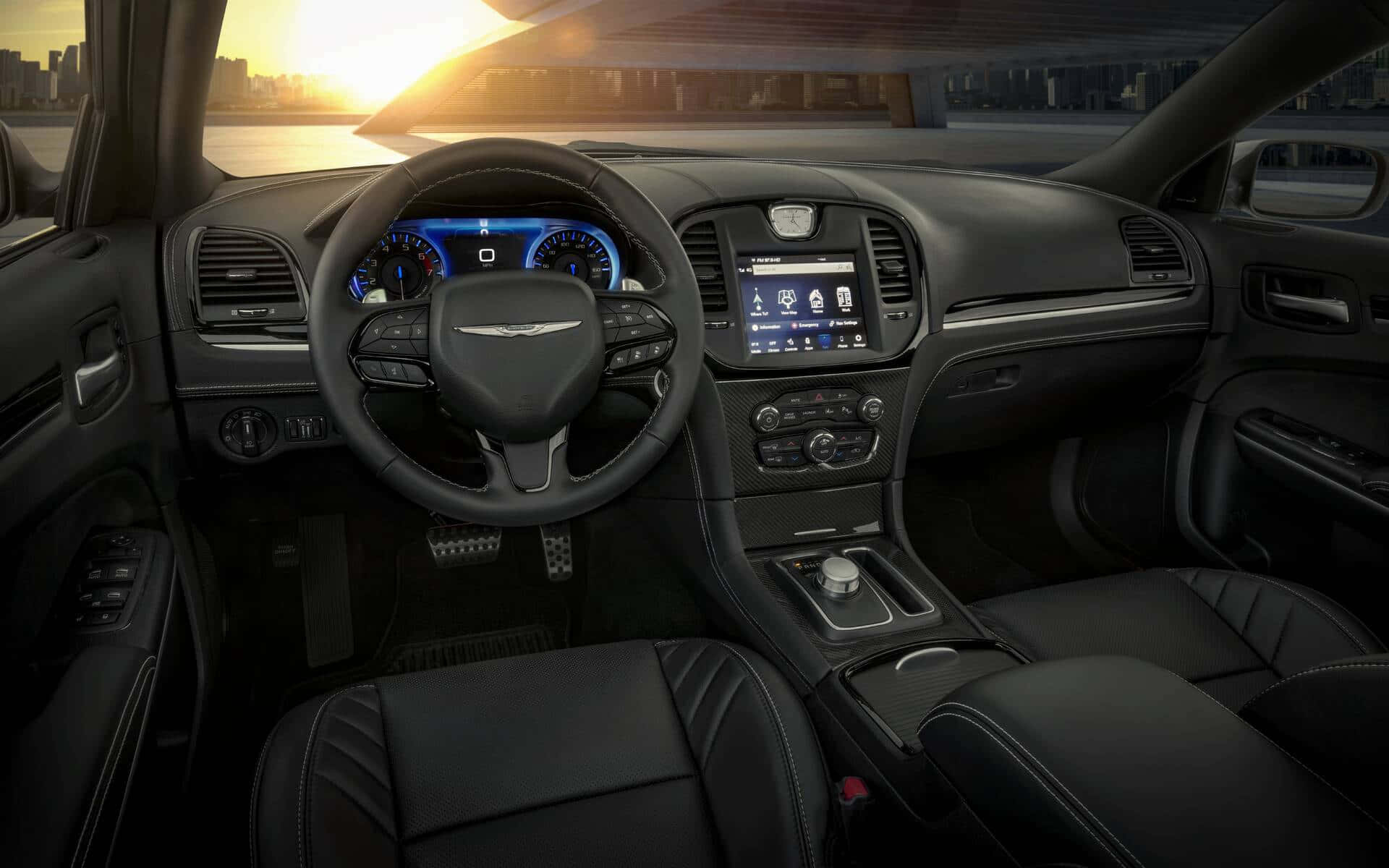 Chrysler 300 桌布 壁紙 — 豪華車內裝在日落時分，帶有發光藍色儀表板，透過擋風玻璃可見城市天際線。