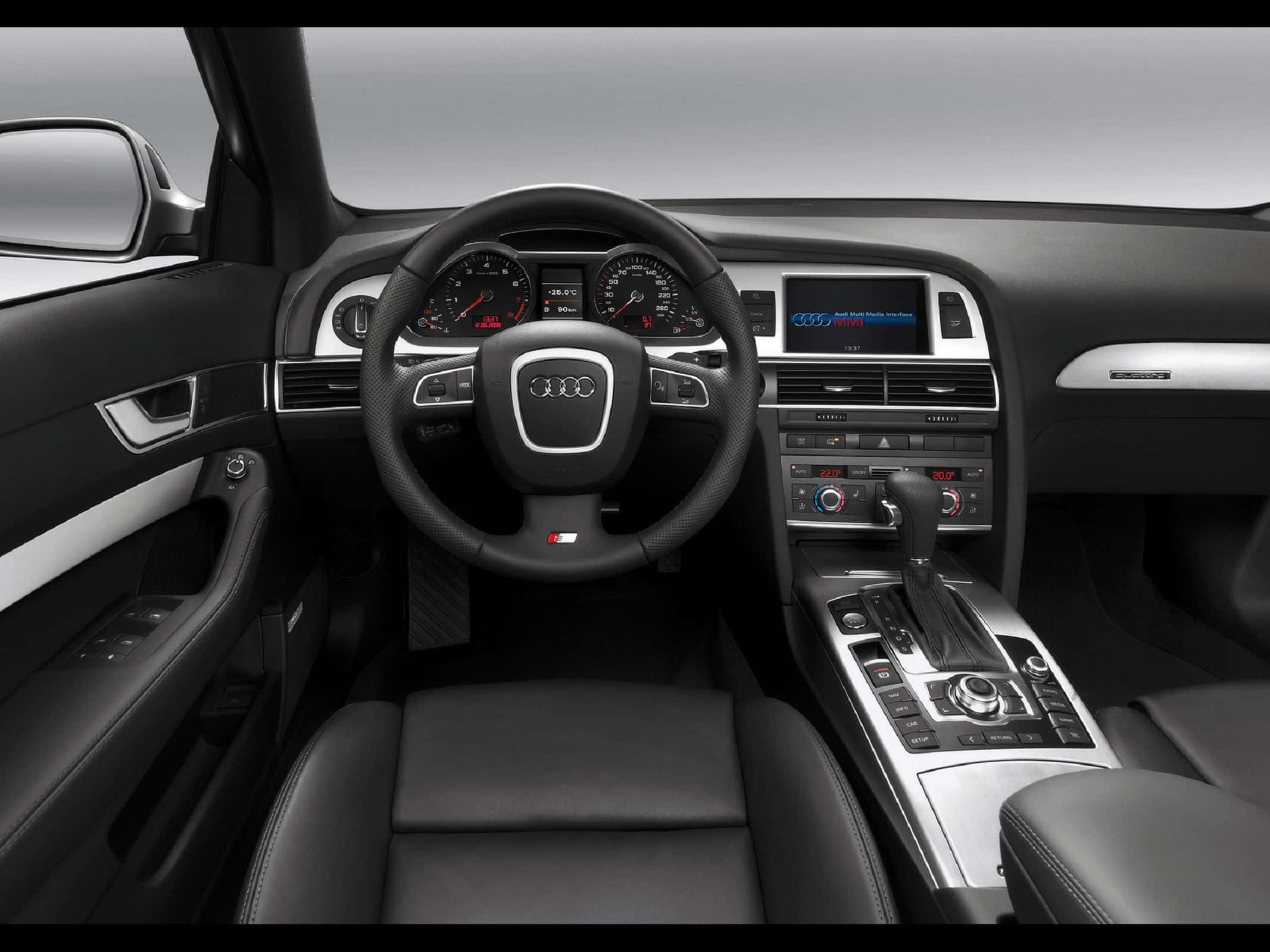 Audi A6 桌布 壁紙 — 豪華車內裝，黑色皮革座椅和銀色裝飾，展示奧迪現代儀表板和方向盤。