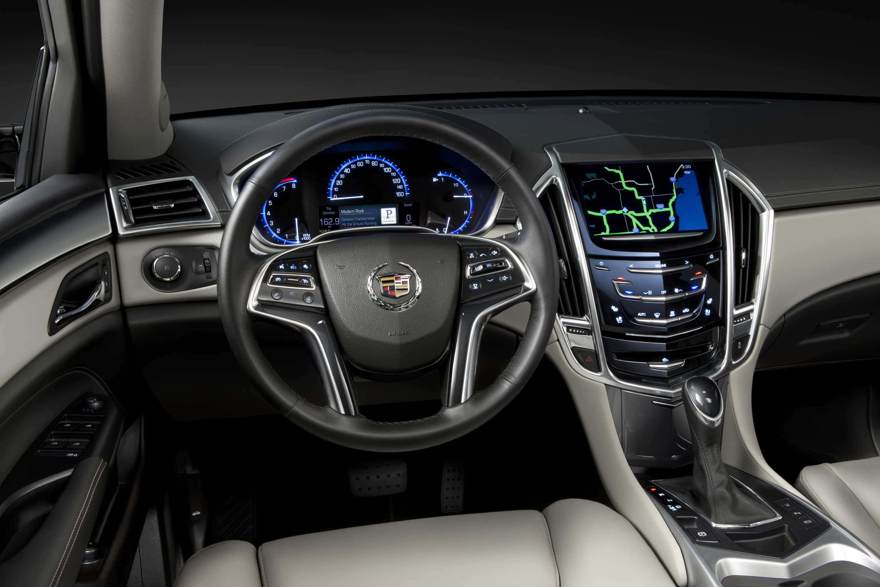 Cadillac Srx 桌布 壁紙 — 豪華車內裝，配有藍色發光儀表板和米色皮革座椅，在工作室燈光下。