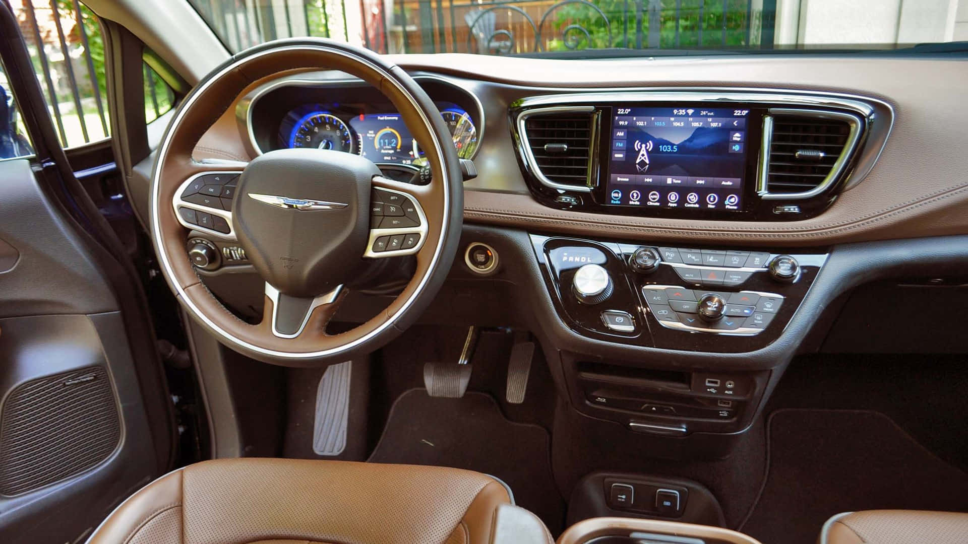 Chrysler Pacifica 桌布 壁紙 — 豪華車內裝，配備棕褐色皮革座椅和顯示導航及車輛統計數據的數位儀表板。