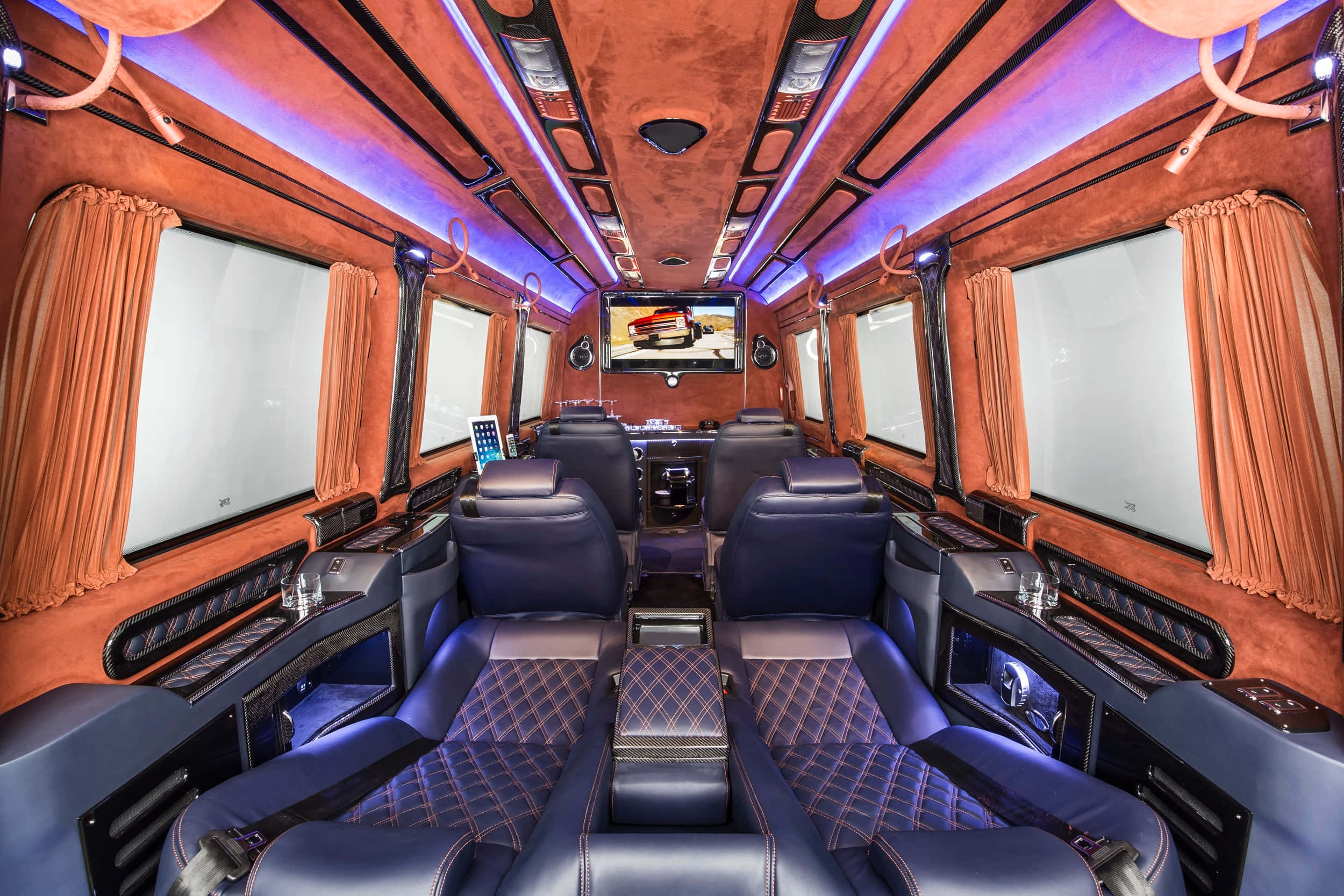 Mercedes Benz Sprinter 桌布 壁紙 — 豪華轎車內部，配有柔軟的藍色座椅，紅色縫線絎縫，橙色天鵝絨牆壁和紫色LED照明。