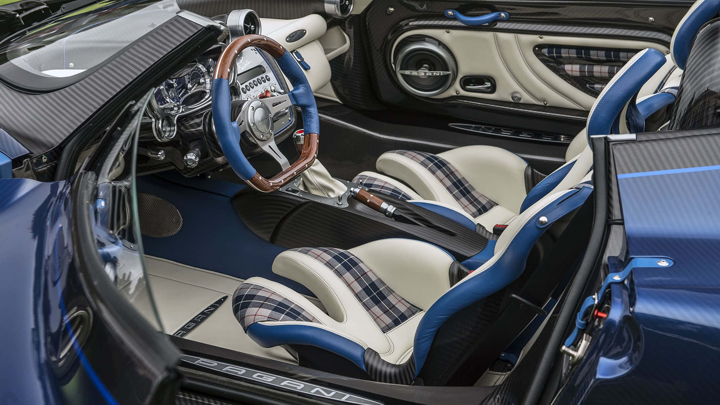 Pagani Zonda Hp Barchetta 桌布 壁紙 — 豪華跑車內裝，配備藍色和奶油色格紋座椅、碳纖維飾邊和木質方向盤。