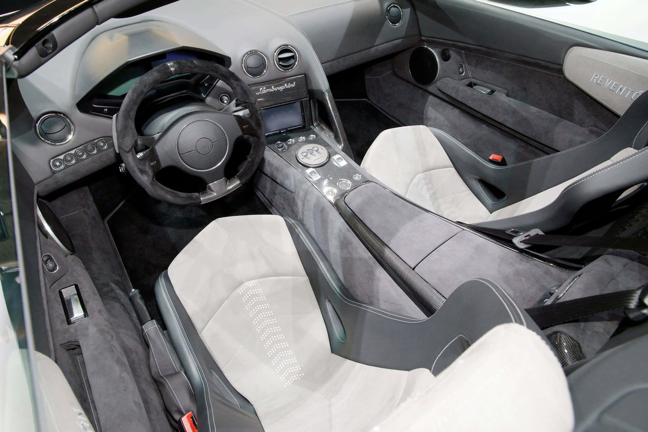 Lamborghini Reventón 桌布 壁紙 — 豪華跑車內裝，配備灰色絨面座椅和黑色碳纖維飾邊，展現高端工藝。